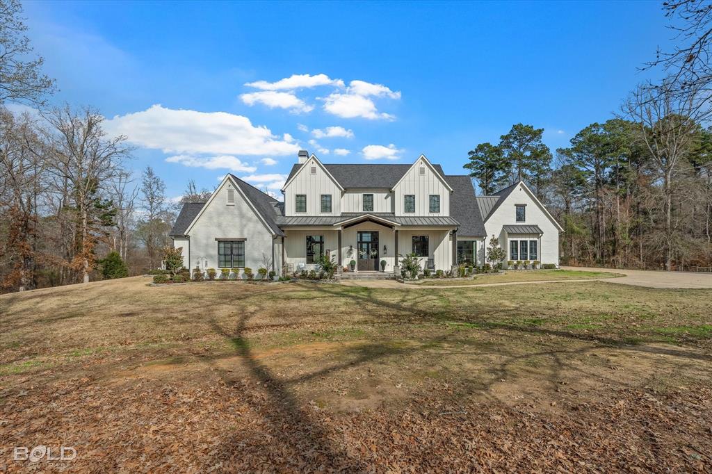 This extraordinary custom-built estate, where luxury meets country living on 29 acres. Privately tucked away and zoned Residential Agricultural, this remarkable property offers the perfect blend of elegance, recreation, and opportunity, ready for horses with ample room to build a shop or barn. Spanning an impressive 6,131 square feet, built in 2019 this stunning home features 4 bedrooms (2 upstairs & 2 downstairs), 5.5 bathrooms, and a thoughtfully designed layout ideal for both everyday living and grand entertaining. ALL bedrooms include their own en-suite bathroom, providing comfort and privacy for family and guests. From the moment you arrive, the architectural detail captivates, soaring ceilings, exposed beams, rich wood accents, and walls of windows framing panoramic lake views. The expansive living area centers around a floor-to-ceiling stone fireplace, creating a warm yet sophisticated gathering space. The chef’s kitchen is a showpiece with custom cabinetry, premium appliances, oversized island seating, and timeless finishes that perfectly complement the home’s modern farmhouse aesthetic. Step outside to your private resort-style oasis. A stunning pool and spa overlook the lake, offering the ultimate backdrop for sunset evenings and weekend entertaining. The outdoor living space includes a fireplace and full outdoor kitchen area with garage-style doors that seamlessly blend indoor and outdoor living. The primary suite is a retreat of its own, featuring a spa-inspired bathroom and breathtaking water views. Upstairs, additional bedrooms and a dedicated theater room provide the perfect space for relaxation and entertainment. With rolling acreage, lake frontage, mature trees, and endless potential for equestrian pursuits, this property offers the rare opportunity to enjoy privacy, luxury, and land, all just minutes from town. This is more than a home, it’s a legacy estate designed for those who want space, serenity, and sophistication without compromise.