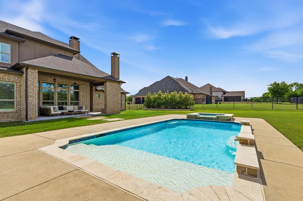 Welcome to Waterstone, a 680-acre gated luxury community tucked into the rolling hills just 12 minutes from downtown McKinney and a short drive to the new HEB in Melissa and all the commercial growth along 75. No city property tax. This Cour de Chateau French Country home sits on a full acre of heavily treed land surrounded by 4 lakes and the kind of quiet you don't find in the suburbs anymore. A charming front courtyard welcomes you in off the front patio. Inside you'll find an open floor plan with formal dining, a raised private study with Juliet balcony, a dedicated media room, game room, and a bar with wine storage. 4 bedrooms, 4 full baths, plus a pool bath. Marble counters throughout. Every room has a purpose. Out back, a gorgeous covered outdoor living area with fireplace overlooks the pool and spa. The yard is mature, heavily treed, and feels like your own private retreat. The 3-car oversized garage features epoxy flooring and a dedicated EV charger. Foam insulation and a tankless water heater keep this home running efficiently year round. Fiber internet is available on the street for anyone working from home or needing serious connectivity. This is peaceful country living with every luxury detail handled. Welcome home.