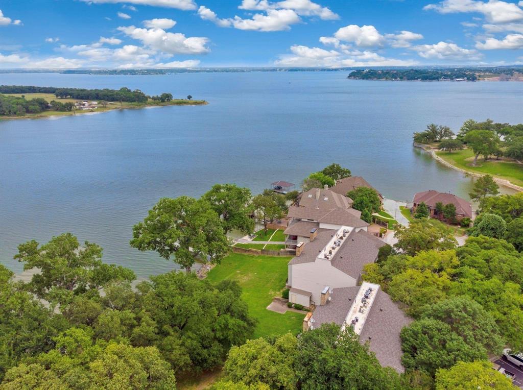 Open Water Eagle Mountain Lake Condo, remodeled and well designed, just move in and enjoy full time or as a weekend getaway! The Timbers Condos have their own private community dock with large lake front green space to enjoy the water and the amazing sunsets. Eagle Mountain Lake Marina is just over a mile, 4 minutes, away as well as multiple lake beach parks within a short drive. Two story condo (starts on second floor) with two balconies overlooking the lake and another balcony off the second primary overlooking front green space. Kitchen with eat in area opens to spacious living area with amazing water views and a balcony over looking the lake. Upstairs you have both of the primary bedroom suites each with their own bathroom and balcony. There is a large personal front door patio area with exterior storage closet as well. The condo is a part of a very small complex, very quiet and peaceful neighborhood. Only 20 minutes (drive) to Ft. Worth Boat Club and 25 minutes to the Ft. Worth Stockyards and all the dining and entertainment of downtown Ft. Worth! (About 37 minutes to DFW airport.) Eagle Mountain Lake is an active - true Lake Life getaway still close to town!