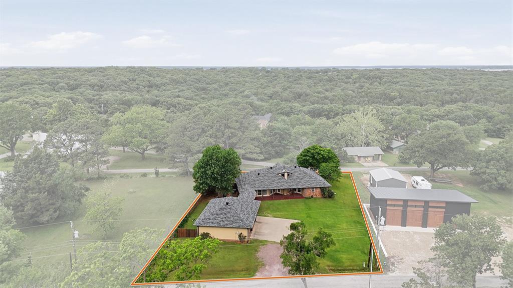 Welcome to your Lake Texoma escape, where towering pines, fresh air, and wide-open space create a lifestyle most people only dream about. Nestled on nearly half an acre in the sought-after Coffee Circle community, this one-story retreat blends comfort, function, and that unmistakable “I never want to leave” feeling.

Step inside and feel the space. A thoughtfully designed 4-bedroom, 3-bath layout offers room for everyone—whether you're hosting weekend lake guests or settling in full-time. The kitchen anchors the home with a generous layout, breakfast area, and easy flow into the living room, where a wood-burning stove sets the tone for cozy evenings after a day on the water.

The primary suite is your private sanctuary—spacious, quiet, and complete with an en suite bath, dual closets, and a rare bonus: a FEMA-engineered safe room built to withstand up to 200 mph winds. It’s peace of mind you didn’t know you needed—until now.

Out back, the oversized deck becomes your everyday escape. Morning coffee under the pines. Evening gatherings under the stars. This is where memories are made.

And then there’s the garage—an oversized three-car setup with serious workspace, connected by a breezeway for convenience and character. Bring your tools, your toys, your lake gear—there’s room for it all, including an RV electric hookup ready to go.

But the lifestyle doesn’t stop at your property line. Coffee Circle offers two sandy beach access points and a scenic hike-and-bike trail, giving you direct access to everything that makes Lake Texoma one of North Texas’ most loved destinations.

This isn’t just a home.
It’s a lake lifestyle, a retreat, and a smart investment all wrapped into one.

Opportunities like this don’t sit—they move.