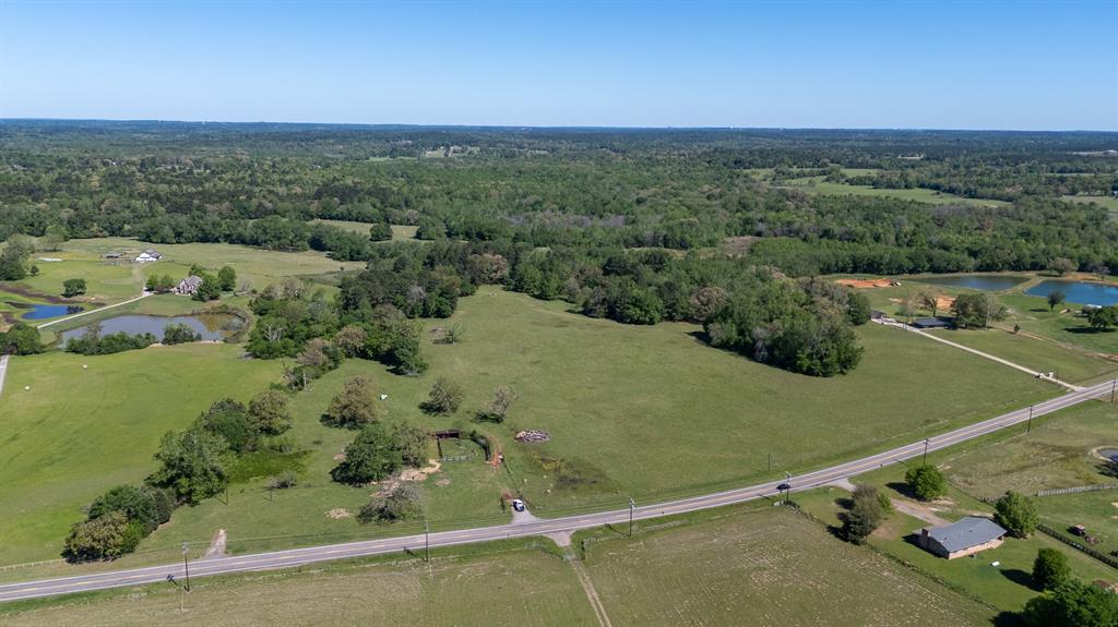 This 31-acre farm and ranch tract in Smith County fronts FM 344 two miles east of Bullard, Texas. Approximately one-quarter mile of road frontage runs along FM 344, with a large municipal waterline and electrical service available at the county road boundary. Massive scattered hardwood trees stand throughout the property, providing canopy across a landscape that transitions from flat open ground to gently rolling terrain, including a distinct hilltop position. A natural spring feeds the north corner of the tract and represents a dependable water source for livestock, wildlife, or home site planning. The mix of open ground and timber cover is characteristic of the southern Smith County agricultural corridor along FM 344. The property currently carries an agricultural exemption. A family seeking a home site with room for cattle or horses will find the elevation, hardwood canopy, and spring water this is the spot. White-tailed deer and other native wildlife filter through the hardwood bottom. The property is 2 miles from Bullard, approximately 15 miles south of Tyler, and roughly 112 miles east of Dallas. Invest in Texas Buy Land!