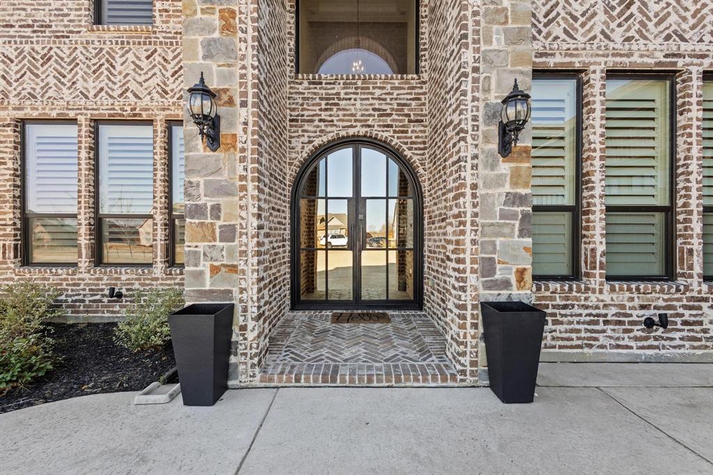 Welcome to 105 Shawnee Trail, located in one of Pottsboro’s most sought-after communities—just seconds to grocery, schools, and restaurants, and minutes from Lake Texoma.  This stunning 6 bed, 5 bath, 4,508 sq ft home on a half acre lot offers the perfect blend of luxury and everyday comfort. From the grand brick-and-stone exterior to the beautiful arched entry, this home delivers unforgettable first impressions. Inside, you’ll find a bright, open living space with soaring ceilings, wood beams, and a gorgeous stone fireplace. The chef’s kitchen features a 6-burner gas cooktop, double ovens, coffee bar, custom cabinetry, and an impressive 16' island—plus a hidden 6' x 13' walk-in pantry. A rare layout with two primary suites—one up and one down. The downstairs suite includes a 17' x 14' closet and serene backyard views. Additional highlights: 3-car garage, dedicated office, split bedroom design, exquisite finishes throughout.