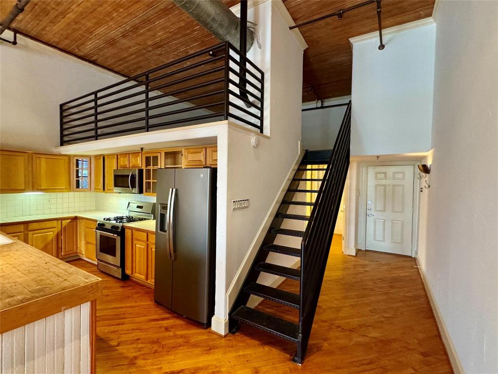 Experience true urban living in the heart of Deep Ellum with this unique loft-style condo just minutes from Downtown Dallas. Featuring soaring ceilings with exposed wood beams, industrial ductwork, and an open-concept layout, this space perfectly blends modern comfort with historic character. The spacious living area flows seamlessly into a well appointed kitchen with ample cabinetry, stainless steel appliances, and a large island—ideal for entertaining or everyday living. Upstairs, a versatile loft overlooks the main living space, offering the perfect setup for a bedroom, office, or creative studio. The oversized bathroom features dual vanities, a soaking tub, and a striking glass block shower, adding both function and style. Enjoy skyline views from the rooftop deck, providing a private outdoor escape in one of Dallas’ most vibrant neighborhoods. Located in the heart of Deep Ellum, you’re steps away from top restaurants, live music, art galleries, and nightlife, with easy access to Downtown, Baylor, and major highways. This is city living at its finest—perfect for those seeking character, convenience, and an unbeatable location.