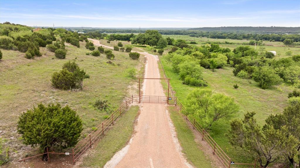 Experience the ultimate Texas homestead just north of Glen Rose! This Ag-Exempt, 22.5-acre property offers some of the most stunning, panoramic views in Somervell County, providing the perfect backdrop for country living. Fully prepared for your animals, the land features both perimeter and cross-fencing for easy pasture rotation, a calf shed, and conveying feed and water troughs. Property is loaded with deer, turkey and dove. The 1,200 sq. ft. main home offers 2 beds, 2 baths, and a durable metal roof. Adjacent via a covered breezeway is a 1,200 sq. ft. heated and cooled shop—a versatile space complete with full laundry hookups and a full bathroom. Behind the shop, you’ll find a private patio featuring a hot tub (conveys!) positioned perfectly to soak in the sunsets. Outdoor highlights include a seasonal pond shaded by a magnificent 300+ year-old Live Oak and a larger pond on the southwest acreage. With full RV hookups, a private well (servicing the home and calf shed), and a generator transfer switch, this property is as self-sufficient as it is beautiful. Enjoy the peace of the country with modern accessibility: located just 30 minutes from the Chisholm Trail Parkway, putting you in downtown Fort Worth within an hour. Property physical and mailing address is Granbury, but located in Somervell County allowing students to attend Highly-rated Glen Rose ISD schools.
