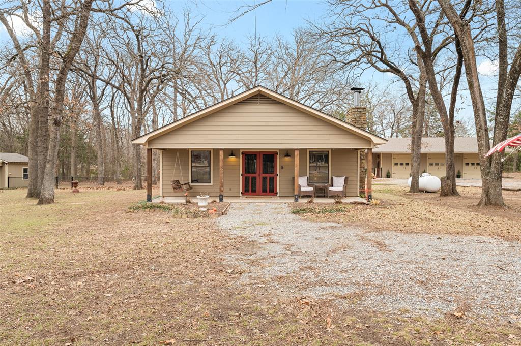 Experience the perfect blend of modern farmhouse style and rustic charm at this stunning property on 1.95 wooded acres in East Denison. Nestled on a serene corner lot, this home offers an inviting open floorplan with two spacious living areas—one featuring a cozy brick fireplace and the other a wood-burning stove with abundant natural light. The kitchen boasts stainless steel appliances, a gas range, a new dishwasher, butcher block countertops, a tile backsplash, and a walk-in pantry. Rustic details, including wood accent walls, add warmth and character to the home.  The heated and cooled 44 x 28 shop with 3 bay doors is a standout feature, complete with a sink, cabinetry, countertop space, and a large TV with a sitting area—perfect for entertaining! Outdoor living is a dream with a large wrap-around back porch, a fire pit area, and peaceful wooded surroundings. This property offers the tranquility of a country setting while being conveniently located near Denison amenities. Don’t miss this exceptional opportunity to own a property that combines style, comfort, and natural beauty.  Looking to get into a home with no money down-This one is outside the city limits and should qualify for a USDA loan!!!