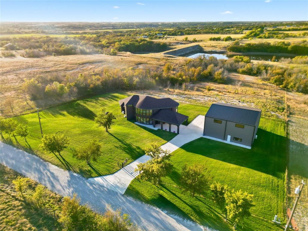 Experience the ultimate in country living in this stunning home completed in August 2024, situated on 5 sprawling acres with breathtaking views of the surrounding countryside. 2 fully fenced and gated acres of lush lawn offer the ideal setting for pets, family, and outdoor entertaining, fully irrigated with high-efficiency Hunter rotors and illuminated with LED landscape lighting for magical evenings under the stars. Step inside to a bright, open floor plan capturing natural light through full-height picture windows, highlighting a seamless blend of modern style and thoughtful craftsmanship. Every detail has been considered, from premium appliances, to dimmable LED lighting and whisper-quiet 22 SEER mini-split heat pumps in every room. The home includes a full mother-in-law suite with its own kitchen, living room, workspace, and separate bedroom, providing private accommodations for guests or extended family. Two tankless water heaters provide unlimited hot water and strong pressure throughout. The open interior flows effortlessly, with neutral tones creating a serene atmosphere, while the covered patio and expansive upper deck allow you to enjoy stunning sunsets and peaceful surroundings. The 5,000 sq. ft., two-story insulated shop offers endless possibilities, including a 30x30 garage, hobby room, mechanical shop, full bath, freight elevator, RV hookups, and a completely open second floor ideal for hobbies, entertainment, or workspace. Remote-controlled solar-powered entry gates, chain-link and wire fencing, flood lighting, and thoughtfully designed outdoor spaces enhance the property. Every element—from ZIP-sealed exterior sheathing, R24 foam insulation, and 2x6 construction to high-efficiency windows and energy-saving systems—ensures comfort, durability, and low utility costs. This home blends modern luxury and peaceful country charm, where every day feels like a retreat surrounded by nature, wildlife, and endless opportunities for work, play, and relaxation.