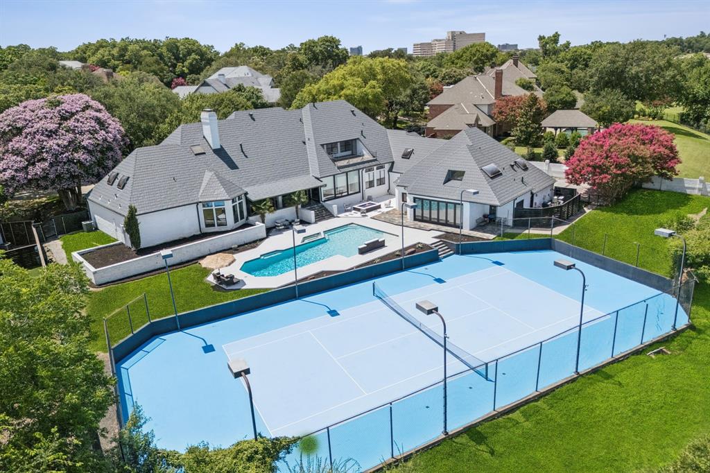 Executive Elegance Meets Resort-Style Living in Williamsburg Estates
Nestled on nearly one acre in the prestigious, tree-lined enclave of Williamsburg Estates, 14208 Hughes Lane is a 12,146 square foot estate designed for both grand entertaining and elevated family living. With its commanding presence and refined finishes throughout, this residence delivers the ideal balance of luxury, comfort, and seclusion—just minutes from Downtown Dallas.
Step inside to find multiple living and dining spaces, a true chef’s kitchen, executive study, game and media rooms, a home gym, and nanny quarters—all crafted with premium materials and thoughtful design. Soaring ceilings and custom architectural details enhance the home’s expansive yet intimate feel. Outdoors, this entertainer’s dream continues with a lighted tennis court, sparkling pool and spa, cascading waterfall, fire pit, and manicured greenbelt views—all in a private, executive-friendly neighborhood known for its large lots, peaceful setting, and close-knit community of high-level professionals. Whether hosting a formal dinner, a backyard celebration, or simply enjoying a quiet evening with family, this home offers the space, style, and sophistication to match any occasion.