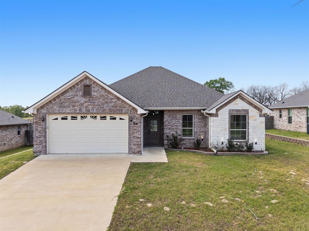 Located in the desirable Nolan Farms community, this thoughtfully crafted 3-bedroom, 2-bath home blends timeless finishes with a layout designed for modern living. Completed in 2022, the home features a striking combination of brick and stone, complemented by classic rooflines and a welcoming front porch. Inside, the space opens up beautifully with vaulted ceilings and an easy, natural flow between the living, dining, and kitchen areas. The kitchen is both refined and functional, offering granite countertops, stainless steel appliances, custom cabinetry, and a generous island ideal for hosting or everyday life. The primary suite creates a true sense of retreat, complete with dual vanities, a soaking tub, a tiled shower, and well-sized walk-in closets. Additional highlights include luxury vinyl plank flooring, a sprinkler system, a two-car garage, and a fully fenced backyard ready for pets, play, or quiet evenings outdoors. With community features like a stocked pond, pavilion, and playground - and a location just minutes from Tyler and Lindale - this home offers a lifestyle that feels both elevated and convenient. Schedule your showing today!