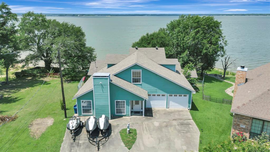 Lakefront living at its BEST!!  Well appointed, cozy, comfortable lakefront home with stunning views, breathtaking sunsets, abundant birdlife and all the needed features for entertaining just yourself or up to 16.  Five bedrooms, including a garage conversion with custom built beds and game room space. Primary and garage bedroom on first level, remaining 3 bedrooms upstairs, including one as a loft overlooking the family room.  Three full baths.  Two very large and multi-functional living areas, a fireplace, wet bar, too many built-ins to describe.  Both the loft and garage bedroom have custom built beds. Kitchen and dining combo room with a table that seats 12.  Views of the lake from the entire back of the house.  Partial wrap around deck, ending in a huge screened in porch set up for dining, games and just relaxing.  Al-Fresco dining in the back yard, fire pit and yard space left over.  Cul-de-sac lot that widens across the back to give expansive water views.  Boat dock but is need of repair. Vacation rental history is available upon request.  Primarily used by owners.  This property is what lake living and enjoyment is supposed to be - carefree, easy, relaxing, comfortable.  Make it yours.  **NOTE**:  Home sold turnkey with all furnishings remaining in the home.  Jet-Skis are for sale separately - inquire for pricing.