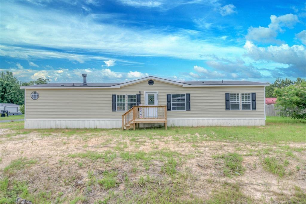 Welcome home to peaceful country living in desirable Willworth Oaks! This spacious 2002 Southern Energy manufactured home offers 3 bedrooms, 2 bathrooms, and an open-concept floor plan designed for comfortable everyday living and entertaining.

The oversized kitchen is the heart of the home, featuring abundant countertop space, ample cabinetry, and room for gathering with family and friends. The inviting living room boasts a cozy corner fireplace, built-in shelving, and plenty of natural light.

The remote master suite provides privacy and relaxation, complete with a large walk-in closet and an ensuite bath. A convenient laundry room with utility sink adds extra functionality to daily life.

Enjoy the outdoors from not one, but three porches—two in the back and one welcoming front porch—perfect for morning coffee, evening sunsets, or entertaining guests. Situated on a large corner lot, you'll have plenty of space to enjoy country living while remaining just minutes from shopping, dining, and city conveniences.

Affordable, move-in ready, and eligible for VA financing, this property offers the best of both worlds—quiet country charm with easy access to everything you need. Schedule your private showing today!  Owner is licensed real estate agent.