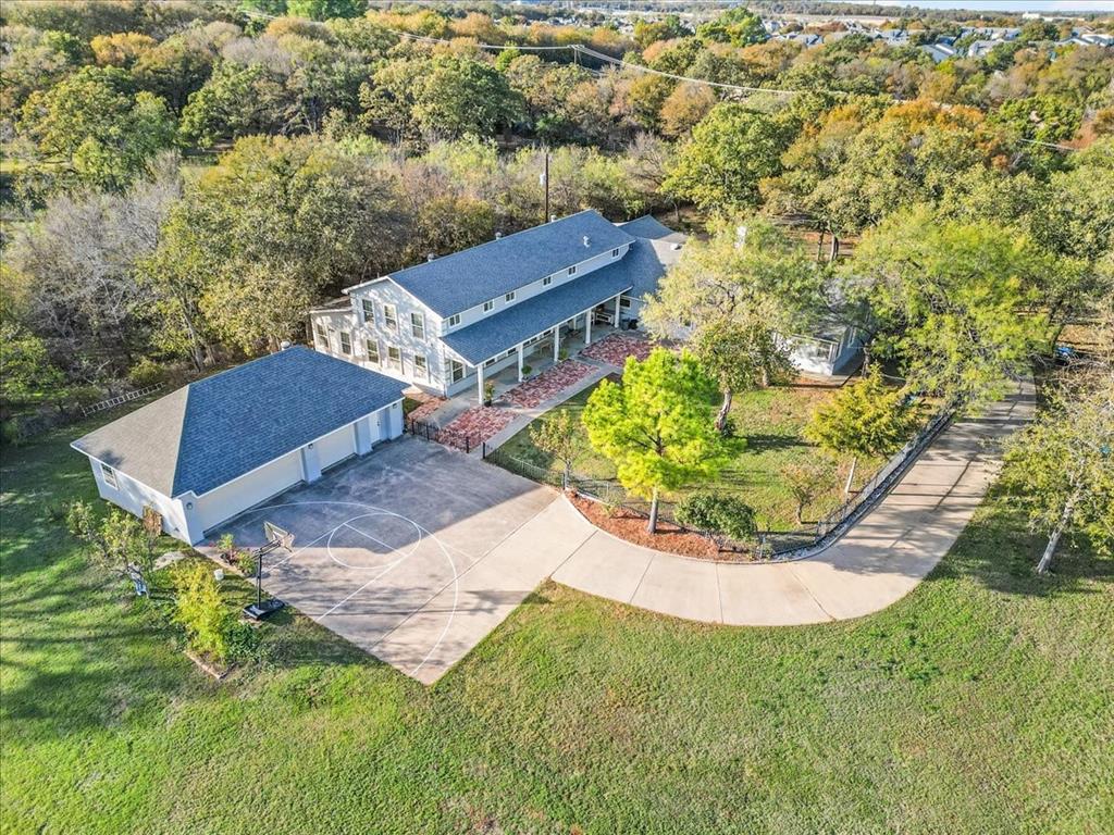 SELLER OPEN TO SELLER FINANCING AT 5% INTEREST. FULL APPRAISAL REPORT FROM MAY 2025 AVAILABLE. Tucked behind a gated entrance on 2.23 beautifully landscaped acres spanning two lots, this one-of-a-kind property offers an exceptional blend of privacy, space, and versatility. Originally built in 1956 and thoughtfully expanded in 2010, the home features a spacious, flexible floorplan designed to accommodate a variety of lifestyles and needs. Inside, you'll find two oversized living areas, including a stunning main living room with soaring 16-foot ceilings that create a grand yet welcoming atmosphere. The open-concept layout seamlessly connects the living, dining, and kitchen spaces, making it ideal for entertaining, large gatherings, or everyday living. Generously sized rooms throughout the home provide endless possibilities, including multigenerational living, home offices, hobby spaces, or business use. The oversized 41' x 22' three-car garage with workshop area offers abundant room for vehicles, storage, and projects. Outside, the park-like setting is truly special, featuring mature trees, lush landscaping, and a variety of fruit trees that enhance both the beauty and functionality of the property. The gated entrance and thoughtful placement of the home create a private retreat while still being conveniently located near shopping, dining, and easy access to I-30. The expansive grounds offer plenty of room for recreation and future improvements, including a pool, tennis court, guest house, or additional outdoor living spaces. A basketball court is already in place, providing fun for all ages. In addition to its residential appeal, this unique property may also be well-suited for certain commercial or live-work uses, offering flexibility rarely found in such a desirable location. Lovingly maintained and full of character, this is more than just a home. It's a private estate with endless possibilities. Some photos have been virtually staged.