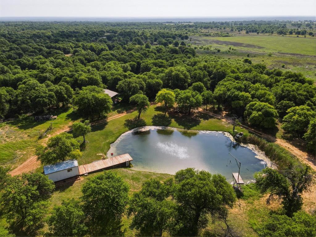 Lazy J Ranch is a private, 52 acre turnkey retreat with a beautiful rock home, mature oaks, miles of trails, and a clear, stocked pond with waterfall and dock. The pond holds water year-round, is fed by a well, and is stocked with largemouth bass, bluegill, crappie, plus a large koi (10+ years) and a large blue catfish.

The timeless rock-built home offers 5 bedrooms, 2.5 baths, and 2,806 SF with views from every room. Features include a three-car garage, safe room, hidden storage spaces, and an existing security system. Appliances to convey: stove oven and dishwasher.

Water: Main well (SW corner) is 40’ deep, rated 100 GPM, pump replaced approx. 1.5 years ago (2 HP), current flow approx. 66 GPM. Second well (south side of pond) rated 5 GPM; no pump installed. Per owner.

Improvements include a solar-powered gate, custom stonework and entrance gate, pond-side shed with power and irrigation pump switch plus 3 water spigots, and a 20’ x 40’ open-front tractor shed. Attic has approx. 2–3’ blown insulation.

Utilities: Big Country Electric, Hawley Water Co-op, County Waste, and Taylor Telecom fiber optic internet. Septic pumped 2.10.2025; cleanout located behind home near primary bedroom window. County Rd 348 is graded regularly (monthly or more).