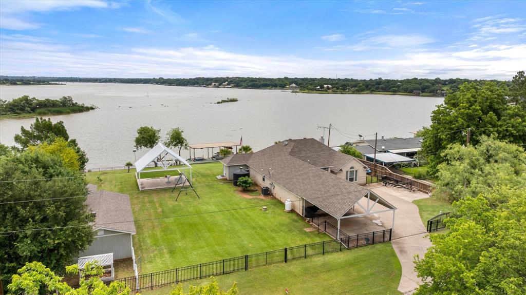 Experience 150 feet of lakefront living at its finest in this beautifully updated home on Lake Granbury! The home features the beauty of panoramic water views; large windows spanning the entire back of the house filling the living spaces with natural light and showcasing breathtaking sunrises every morning. Gorgeous moonlit reflections over the lake are astonishing to look at and enjoy! This approx 2100 sf home offers 3 bedrooms 3 baths and 2 spacious and inviting sunrooms, perfect for relaxing, entertaining or simply soaking up the scenery year-round. The property includes 3-car garage and a 2-car carport providing ample parking for you and guests. Step outside and enjoy the 20’x24’ pavilion ideal for gatherings, a private boat dock and excellent fishing year-round! If work is your hobby, enjoy the large workshop. Whether you’re looking for a peaceful retreat or a place to host family, this lakefront will deliver comfort, beauty and unforgettable memories! More pluses to see! Come on over!