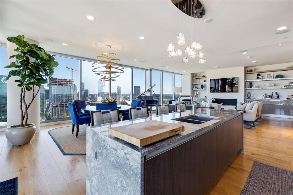 Welcome to the highest level of luxury living in this completely custom, 21st floor corner unit at Blue Ciel. The open-concept living, dining & kitchen offering expansive southern & eastern views of the Dallas skyline, & the multiple private terraces provide ample opportunity to take in the view. The gourmet kitchen features an oversized refrigerator-freezer, Miele appliances, & island with waterfall marble counters. Motorized shades, stately fireplace, & alternate-opening glass doors facilitate entertaining. The main hallway is adorned with an entire gallery for displaying wine.  The primary suite offers a sitting area, private terrace, stunning marble bathroom, & oversized closet. Two secondary ensuite bedrooms, home office, & laundry room complete the home. Blue Ciel offers residents access to a fitness room, yoga room, pool & spa, 24-7 concierge & valet services & as well as direct access to the Katy Trail. Experience the perfect blend of urban sophistication & resort-like living.