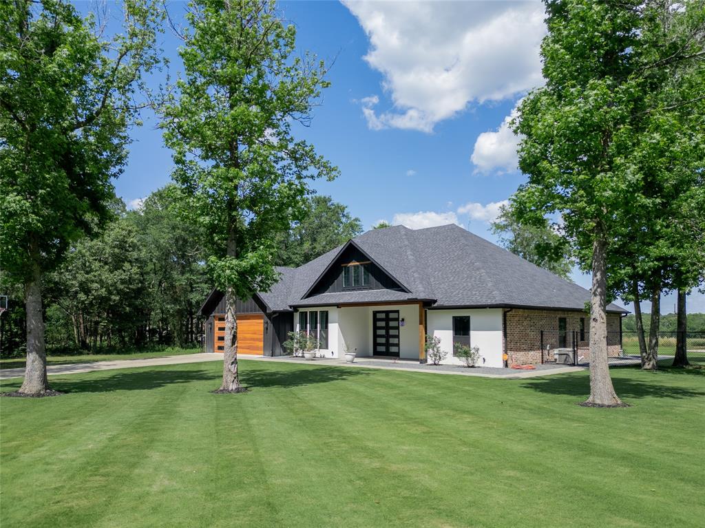 BACK ON THE MARKET DUE TO A CHANGE IN BUYERS CIRCUMSTANCES! NO FAULT TO SELLER!!  Hidden behind a beautiful tree lined entrance on approximately 4 acres, this custom built 2022 home offers privacy, modern finishes, and peaceful country living just minutes from Mineola and Quitman. This 3 bedroom, 2 bathroom home with an office features an open concept layout with soaring ceilings, abundant natural light, and high end custom touches throughout. The stunning kitchen includes two tone custom concrete countertops, black stainless KitchenAid appliances, large island, walk in pantry, and custom cabinetry with pull out drawers and exceptional storage. The spacious primary suite offers a soaking tub, oversized walk in shower with rain shower head, double vanities, and walk in closet with built ins. The oversized heated and cooled 23 x 27 garage provides the perfect flex space for a home gym, workshop, game room, or additional entertaining area. Outside, enjoy expansive covered porches, peaceful acreage views, and beautifully maintained Zoysia grass known for its lush appearance, durability, and soft feel underfoot. The manicured lawn and private setting make this property feel like your own secluded East Texas retreat.