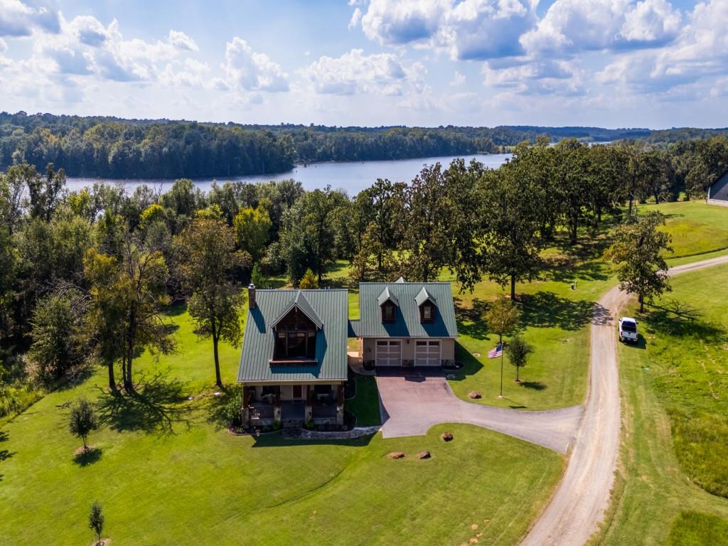 TYLER'S EAST TEXAS LAKE COUNTRY. LAKE RETREAT. WATER VIEWS. A REASON TO LEAVE TOWN.
Just 30 minutes south of Tyler and minutes from Frankston, this waterfront retreat is nestled within the gated community of Caddo Creek Estates, where your morning commute is measured in steps to the porch instead of miles on the freeway, and the loudest part of your morning is the birds. Set on nearly two acres, this Craftsman-style home was designed for one thing: living with the water, not simply near it. Nearly every room captures lake views through new windows. Four spacious bedrooms, each with a private ensuite bath, create a home equally suited for everyday living, unforgettable weekends, and generations of family and friends gathered under one roof. The upstairs primary suite opens to a private balcony with panoramic lake views, while the main living areas flow naturally onto covered porches designed for relaxing, entertaining, and simply letting the day unfold. A detached four-car double-tandem garage with epoxy flooring offers ample space for vehicles, golf carts, hobbies, and lake toys, while the exterior mosquito misting system helps keep evenings on the porch about conversation instead of citronella. Beyond the home, Caddo Creek Estates offers six private, wake-free lakes ideal for kayaking, paddleboarding, quiet fishing, or simply doing nothing at all. Community amenities include a 6,000-square-foot clubhouse, pool, playground, and guest accommodations. Conveniently located approximately 10 minutes from Frankston, 30 minutes from Tyler's renowned healthcare, shopping, dining, and entertainment, with easy access to Athens and Canton, and under two hours from DFW. Whether you're searching for your forever home, an East Texas getaway, or simply a place that reminds you to slow down, Caddo Creek Estates is more than a change of address. It's a change of pace... and life. Furnishings and select non-realty items are available to convey separately.