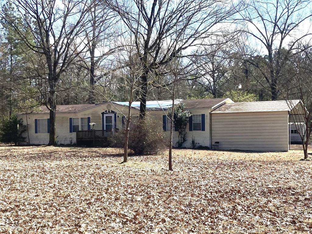A great new place to call Home that sits on 5.33 acres.  Front yard and some of the backyard are cleared with the remaining lot of woods and trees. Great for exploring trails and enjoying the outdoors.  The 5.33 acres lot backs up to a deer lease and there are no back yard neighbors.  If Buyers love lake activities this home is conveniently located near to Caddo Lake Public Launch. This Home has an attached carport with a side entrance hallway leading to utility area and to the kitchen. A covered back porch is great for family living and entertaining. This Home is an open floorplan with a large living area with a wood burning fireplace and a view of the back yard. There is a separate dining area and a kitchen with an island, breakfast bar, along with great cabinets and counters space. The primary bedroom is remote with a nice size bath with walk in shower, garden tub and dual sinks. The other two bedrooms are on the other side of the Home and share a hall bathroom. The property does need TLC for cosmetic repairs. Seller will replace the roof prior to closing but make no other repairs. Other outdoor buildings great for storing riding mowers, 4 wheelers etc. which includes a 30 x 20 metal building and a storage building. This house and 5.33 acres will be a great new place to call Home.