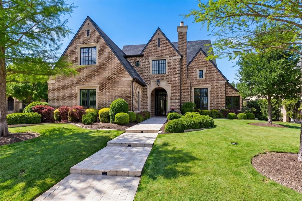 Located in the prestigious guard-gated community of Normandy Estates, this timeless Tudor estate offers nearly 6,000 square feet of refined living with a floor plan designed to function like a single-story home. Built in 2017, the residence features 4 bedrooms, 4 full baths, 1 half bath, and a thoughtfully designed layout ideal for both everyday living and entertaining.

A private vestibule opens to a dramatic grand entry, where a sweeping spiral staircase and custom wine display create an unforgettable first impression. The expansive first floor spans approximately 4,699 square feet and includes the primary living spaces, study, media room, primary suite, and guest suite—all conveniently on one level.

At the heart of the home, the chef’s kitchen opens seamlessly to the family room, where vaulted ceilings with exposed beams and walls of windows create a bright, inviting gathering space. A see-through fireplace connects the living area to the dining space and wet bar, creating a natural flow for entertaining, while the breakfast room is surrounded by windows overlooking the backyard.

The private primary suite is a true retreat, complete with a sitting area, spa-inspired bath, dual walk-in closets, and separate water closets. A secondary guest suite with direct pool access is thoughtfully positioned for privacy and convenience.

Upstairs, two additional bedrooms with en-suite baths are paired with a spacious game room, offering a private escape for guests or family. A large floored attic provides exceptional storage and future potential. Outdoor living is equally impressive, with a covered patio featuring a fireplace and Phantom screens, all overlooking a resort-style pool framed by mature landscaping for privacy and serenity.