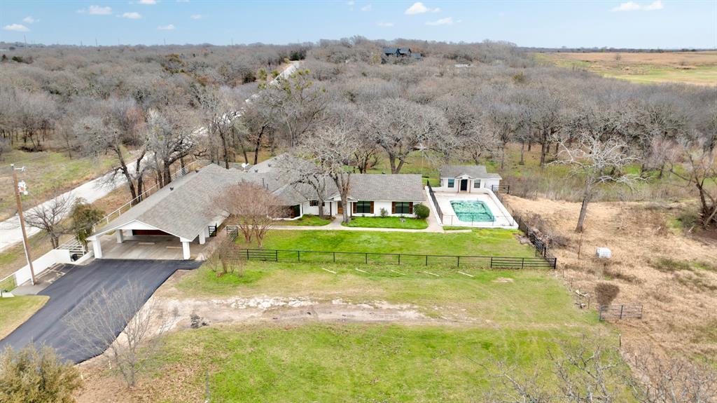 Private 7-Acre Country Retreat with Remodeled Home
Escape to peaceful country living on this private 7-acre property featuring a fully
remodeled 3,660+ sq. ft. home, pond, sparkling pool, pool house, barn, mature oak
trees, and fenced acreage. Updated in 2024, the home offers high-end transitional
finishes throughout, including new flooring, lighting, fixtures, appliances, cabinetry,
countertops, and more.
Inside, you’ll find 4 spacious bedrooms, 3 beautifully updated bathrooms, an oversized
primary suite with two walk-in closets, and an additional en suite bedroom ideal for
guests or multigenerational living. Two flexible living spaces offer endless possibilities
for a game room, home office, guest suite, studio, gym, or private retreat.
The property also includes a large walk-in laundry room, extra-deep 3-car garage with
built-ins and sink, pool house with kitchenette and bathroom, fenced dog kennel, barn,
perimeter fencing, and gated rural-style entrance. With acreage, privacy, mature oaks, a
pool, pond, barn, and versatile indoor and outdoor spaces, this property offers the
perfect blend of modern comfort and country charm.