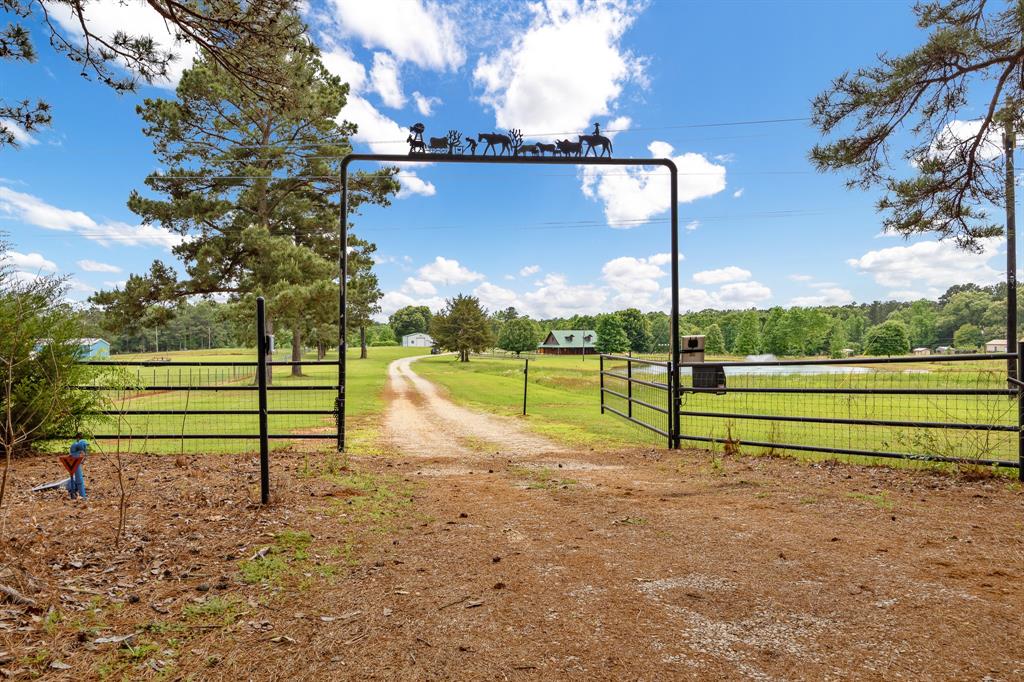 Seller is highly motivated to sell property and has priced to sell. Also, the following items are included (should a potential buyer wish to retain); Large width Zero Turn riding mower (only 10 hours of operation), Side-by-side, Refrigerator, Pond Boat and boat equipment, Port-a-cool, and living room and entertainment area televisions. This exceptional 10+ acre property offers a rare blend of comfort, functionality, and resort-style amenities. The beautifully crafted log home showcases gorgeous wood finishes throughout, a spacious kitchen with granite countertops, and a stunning stone fireplace that anchors the main living area. The expansive primary suite provides a comfortable retreat. Large windows throughout the home capture scenic views of the surrounding landscape.
Outdoor living is equally impressive, featuring a swimming pool with spa and a covered cabana designed for year-round entertaining. The cabana includes a fireplace, television and sound system set up, ceiling fans, and a bar area with equipped kegerator, all protected under a durable metal roof.
The property offers exceptional versatility with a large barn, spacious workshop, and an approximately 2-acre pond complete with a water feature and metal dock. Perimeter and cross fencing, along with a wood-fenced pen area, make it ideal for agricultural, equestrian, or recreational use. Over eight acres (of the 10.329 acres) are currently AG-exempt improved.
A coded security gate enhances privacy and peace of mind. Whether hosting gatherings, enjoying time with family and friends, or relaxing with tranquil pond views, this property delivers an outstanding lifestyle opportunity.