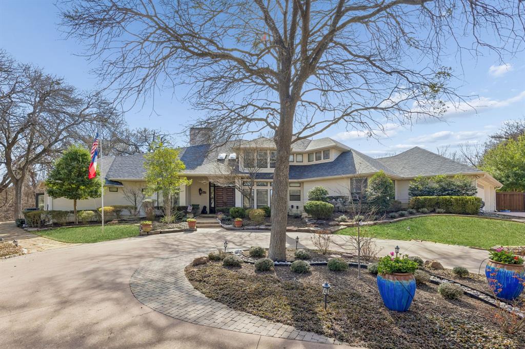 4 Wooded Lane, Allen, Texas is a rare private estate set nearly 500 feet back from the road on 1.47 acres, with forest along two sides—an extraordinary sense of space and privacy in an area known for much smaller lots. From the moment you enter, the home makes a striking impression with 14-foot ceilings, elegant crown molding, and a beautiful view of the two-sided fireplace that anchors the main living spaces. Designed for both everyday living and memorable entertaining, the kitchen features a truly impressive 14x7 island, creating a natural gathering place at the heart of the home. The home offers 5 bedrooms, 5 bathrooms, a dedicated office, 3-car garage, and two upstairs bedrooms connected by a beautifully designed shared bath with separate vanities and a private bath-shower area. A dramatic Juliet balcony staircase adds even more architectural charm. The primary suite is a true retreat, featuring heated floors, his-and-hers 8-foot vanities, his-and-hers toilet closets, his-and-hers walk-in closets, a 9x4 two-headed walk-in shower, and an oversized soaking tub. Just off the suite, a chic she-shed offers the perfect space for reading, tea, coffee, or simply enjoying peaceful wooded views. Outdoor living is just as exceptional, with a circular drive, pool, spa-hot tub, expansive deck, and a climate-controlled wraparound sunroom that invites year-round enjoyment. Warm, expansive, and truly one of a kind, 4 Wooded Lane is a home that offers beauty, privacy, and a sense of legacy rarely found in Allen.