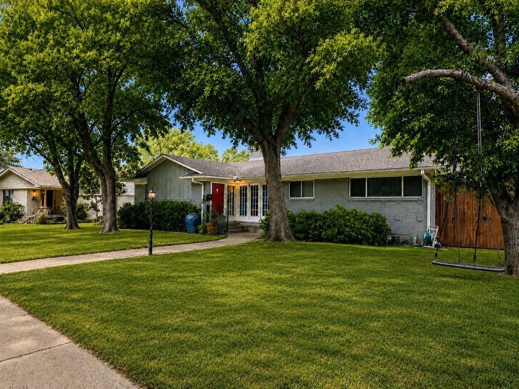 PRICE REDUCTION DUE TO SELLER FINDING HIS NEXT NEW HOME AND IS ANXIOUS TO MOVE!! Welcome to this feel-good Lake Highlands home that blends comfort, flexibility, and great natural light in all the right ways. With two spacious living areas, there is room to host friends, spread out for movie nights, or create the perfect work-from-home setup. The main living space features a cozy fireplace, while the oversized secondary living room stands out with built-ins and a wall of windows that frame the backyard and fill the space with sunshine. The updated kitchen brings clean, modern style with white cabinetry, subway tile backsplash, stainless steel appliances, and a large center island for cooking, gathering, and everyday life. Just off the kitchen, a full-size laundry room with counter space and cabinetry can be closed off with a pocket door, keeping things tucked away when you are entertaining. The primary suite offers a calm place to recharge with backyard access and an updated bath, while two additional bedrooms and a front flex room give you space to grow, work, or host overnight guests. Out back, the covered patio and spacious yard set the scene for relaxed evenings, weekend grilling, or playtime. The porte-cochère, alley access, and electric gate make parking easy and secure. With recent updates, great flow, and a location close to trails, parks, shopping, dining, and all the neighborhood favorites Lake Highlands is known for, this home is an easy one to fall for.