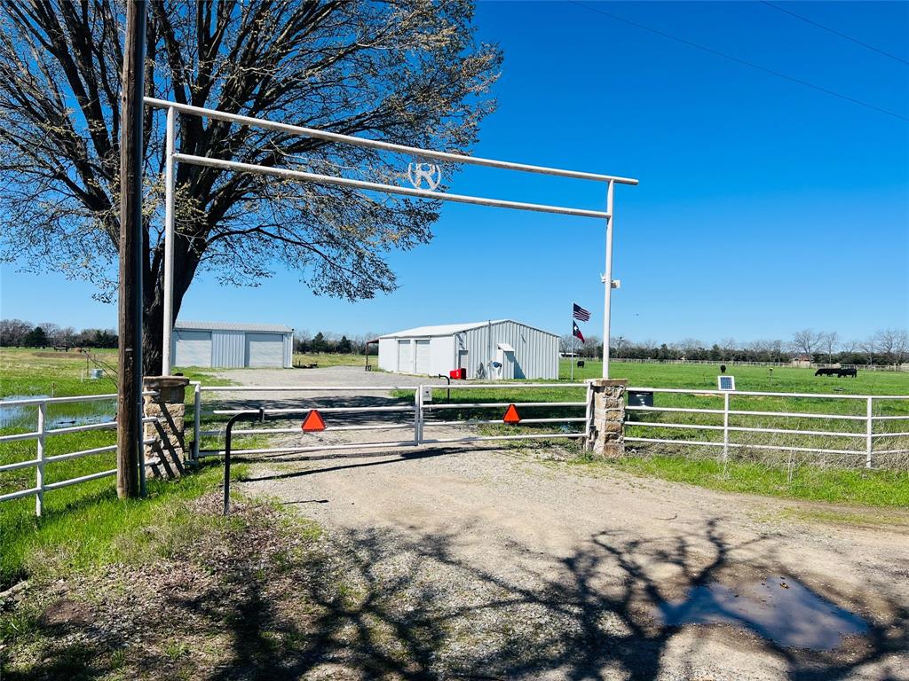 Beautiful 27 acre ag exempt property in Fannin County featuring exceptional improvements and meticulously maintained pastureland. The property includes two fully insulated barns measuring 30x40 and 30x60, both with concrete slabs, water, and electric. The 30x40 barn is fully heated and cooled and includes a bathroom rough-in, making it ideal for a workshop, equipment storage, or future living space. Both barns are equipped with high-output LED lighting for outstanding visibility. Enjoy two stocked ponds, each managed for a specific fishery. The front pond is an aerated and actively managed bass pond, while the back pond is stocked with catfish, offering excellent recreational fishing opportunities. The improved pasture is planted in BDahl grass for strong summer production, with a winter oat cover crop planted seasonally to maintain soil health and forage quality. The property is fully agricultural exempt, keeping property taxes low. Perimeter fencing consists of recently installed drill-stem pipe fencing set in concrete around the road frontage for durability and security and barbed wire around the remainder. Access is through an automatic entry gate with dual openers. Additional features include a rural water meter already installed and extensive gravel improvements (over 8 tons hauled in) providing solid access and usability throughout the property. This is a turnkey North Texas ranch property with excellent grass, water features, quality infrastructure, and strong agricultural productivity—ideal for livestock, recreation, or a private country retreat.