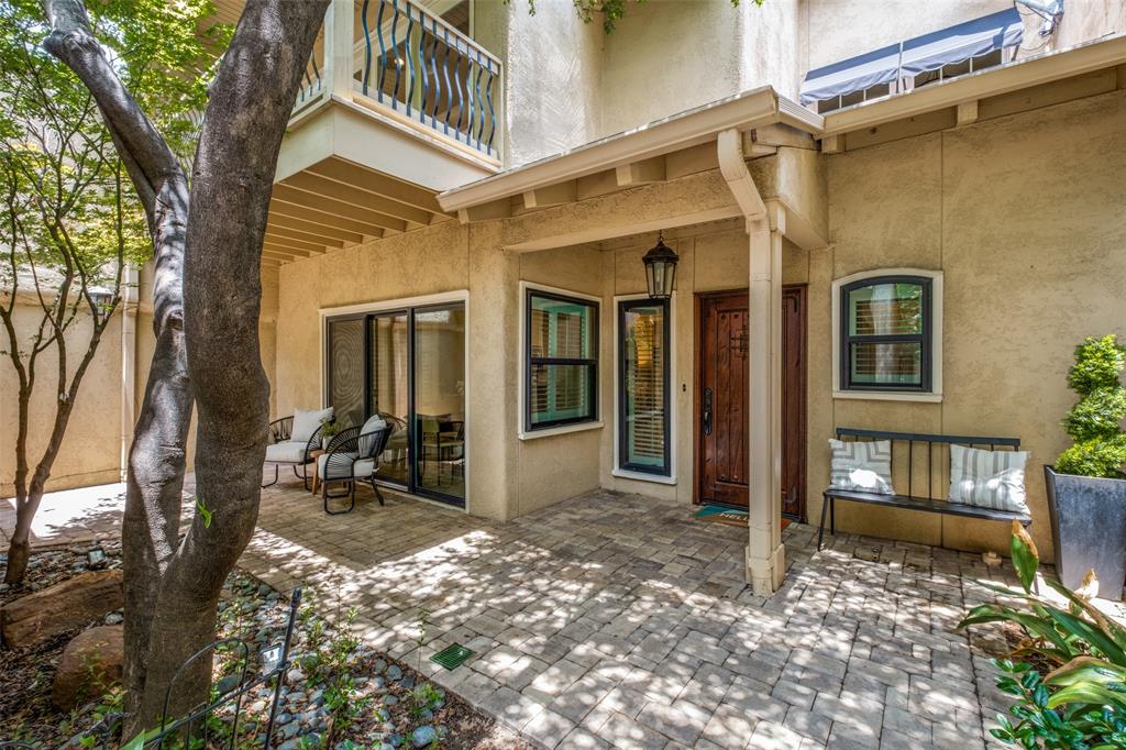 Tucked away on the quiet cul-de-sac of Cochran Chapel Circle, this elegant two-story residence masterfully combines privacy, functionality, and low-maintenance living in one of Dallas’s most desirable Bluffview locations. A secure front courtyard provides privacy and security while creating a charming outdoor retreat perfect for morning coffee or quiet relaxation. Bathed in natural light through soaring lofted ceilings, multiple skylights, and expansive windows, the home features a spacious living room anchored by a wood burning fireplace with classic brick surround, a versatile secondary living area ideal for a library or lounge, and a gourmet kitchen equipped with stainless steel appliances, granite countertops, double ovens, and dual pantries. A bright sunroom flows seamlessly to the private rear patio with hardscape for low maintenance. Upstairs, the split-bedroom layout ensures exceptional privacy. A light-filled office with architecturally framed openings overlooks the living area below, positioned between two generous bedroom suites. The primary retreat offers two walk-in closets, a private balcony and a luxurious ensuite bath with dual vanities, soaking tub, and separate shower. The guest suite includes its own walk-in closet and ensuite bath. Additional highlights include travertine flooring, premium sound-reducing window inserts that deliver a remarkably serene interior, abundant storage throughout, detached two car garage, and effortless two-level living. Just steps from Central Market and premier shopping and dining, this refined home offers sophisticated, lock-and-leave living in an unbeatable location.