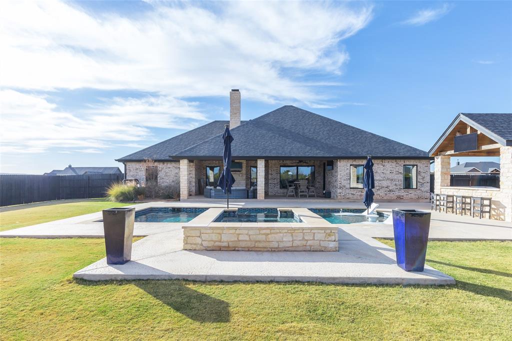 Luxury living meets refined comfort in this exceptional 4-bedroom, 3-bath residence set on 1.69 acres in the highly acclaimed **Jim Ned ISD**. Designed for both everyday living and elegant entertaining, the open-concept layout is enhanced by engineered hardwood flooring and walls of windows that fill the home with natural light.The living room is a true showpiece, featuring a striking full masonry fireplace with gas starter. The gourmet kitchen is outfitted with quartz countertops, a commercial-grade built-in refrigerator and freezer, gas cooktop, double ovens, and an oversized island ideal for gatherings. A thoughtfully designed butler’s pantry with ice maker adds both function and sophistication.The private primary suite offers direct access to the backyard retreat and a spa-inspired bath with tile flooring, soaking tub, tiled walk-in shower, dual vanities, and separate his-and-her closets. The guest wing includes three spacious bedrooms with walk-in closets; two share a Jack-and-Jill bathroom, while a third bath features a beautifully tiled shower. Outdoor living is elevated with meticulously landscaped front and back yards, a circular drive, gutters, and a privacy-fenced backyard oasis. Enjoy resort-style amenities including a swimming pool, hot tub, fire pit, and outdoor kitchen—perfect for hosting or unwinding in total privacy. Additional luxury features include a tankless propane water heater and spray foam insulation for superior energy efficiency and comfort.