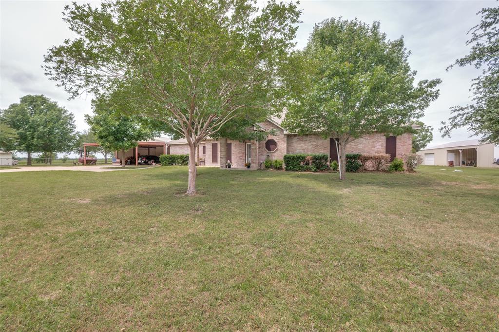 Welcome to your own slice of Texas countryside, where elbow room isn't just a saying — it's a lifestyle. This inviting 3-bedroom, 2-bathroom home offers 2,542 square feet of thoughtfully designed living space with 36-inch-wide doorways for easy access.  Inside, welcoming entryway opens to living room with electric fireplace.  You will love the kitchen built for entertaining complete with island, gas range, two pantries, and two lazy Susans for optimum storage open to the dining area. The spacious primary bedroom delivers convenience with a walk-in closet, dual sinks, built-in cabinets, and a separate shower and tub. The second bedroom features two generous closets, while a dedicated study with its own exterior entrance makes working from home or running a business wonderfully convenient. The oversized utility room, complete with a sink, closet, and built-in cabinetry, makes laundry a breeze.  Now, let's talk about the outdoor space!  A huge, enclosed 25x17 patio sets the stage for year-round outdoor fun. The property boasts an impressive 30x24 insulated garage, a six-car carport stretching 40x29, and not one but three shops, including an insulated 40x37 workshop with a concrete floor, a 36x30 shop with concrete floor and a 40x24 open front shop with concrete floor. Animal lovers will appreciate the 60x32 open-face barn with a chicken coop.  Situated on generous acreage with highway frontage access and just minutes from everyday conveniences, this property serves personal or commercial purposes beautifully.  Schedule your private tour today and experience the perfect blend of country charm and practical functionality firsthand.