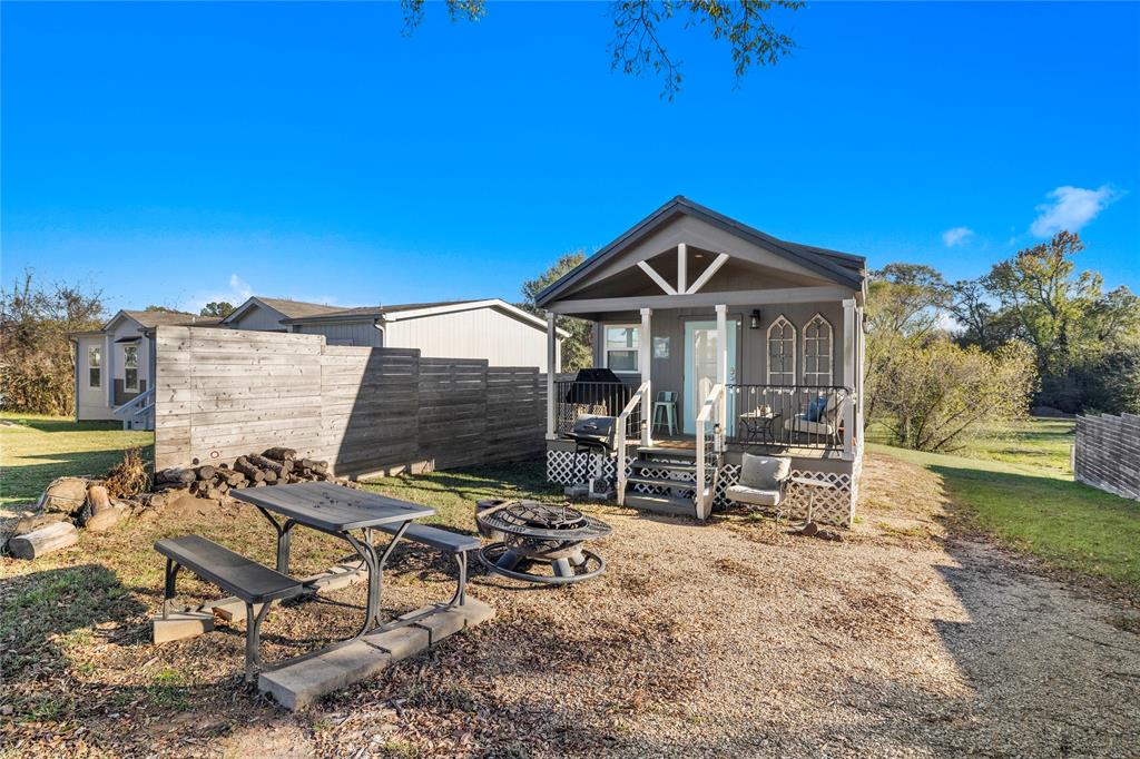Escape to the lake in this adorable 2023 tiny home located in the gated Holiday Village community on world famous Lake Fork. This beautifully designed 1 bedroom, 1 bath retreat offers 416 square feet of smart, modern living and is the perfect weekend getaway, vacation home, or turnkey short term rental opportunity. Inside you will find full size appliances, stackable washer and dryer, stylish finishes, and a comfortable open layout that makes the space feel inviting and functional. Outside, the extended parking area easily accommodates your truck and boat, making it ideal for anglers and lake lovers alike. Spend your evenings relaxing on the covered front porch, grilling with friends, or gathering around the fire pit after a day on the water. Holiday Village offers fantastic amenities including gated security, boat ramps, fishing pier, swimming pool, playground, and community center. Whether you are searching for a peaceful escape or an income producing investment near some of the best fishing in Texas, 339 Indian Gap is ready for you to start enjoying the Lake Fork lifestyle.