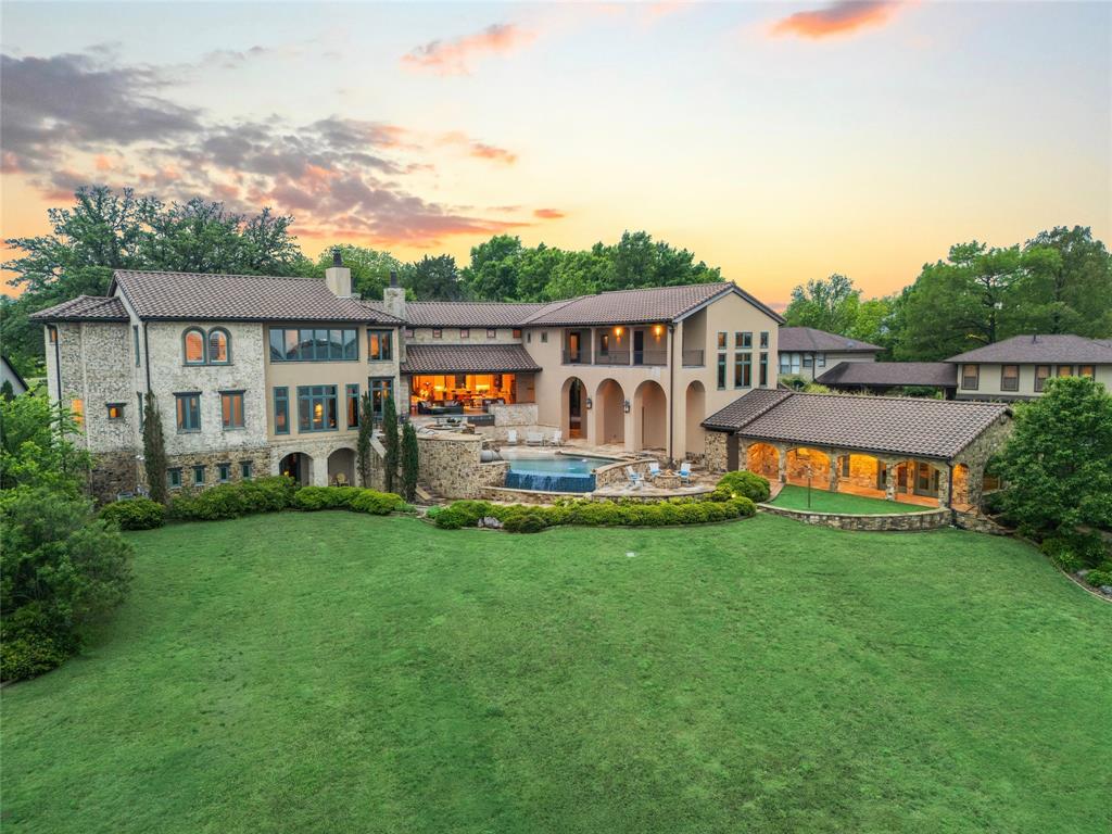 Some homes are built. This one was crafted. Set on the shores of Lake Ray Hubbard in picturesque Heath, Texas with over 400 feet of open water and a private boat dock, this custom Spanish-inspired estate is a single-owner build where every detail was chosen with intention and it shows. At over 7,000 square feet, the architecture honors its Spanish roots through artisan craftsmanship that runs from the exterior stonework and tile roof to the hand-selected interior finishes. The great room anchors the home with the most impressive solid wood beam work, an open-concept flow between the living room, dining room, and kitchen and all framing the lake through a wall of disappearing sliding windows that dissolve the line between inside and out. A stone fireplace grounds the space without competing with the view. The kitchen is built for people who actually cook and enjoy every second of it. Double islands, a chef's gas range, double ovens, a professional-grade refrigerator, and a butler's pantry give you the kind of function that most kitchens only gesture at. The primary suite is its own world: expansive and quiet, with custom woodwork, separate custom closets, a private lake-facing office, a walk-through shower, and a soaking tub positioned to face the lake. This is the kind of room you don't want to leave in the morning. Outside, the multi-level custom pool is designed to be experienced: a negative edge spillway, heated spa, slide, fire pit, and a back patio built for long evenings with people you love. And then there's the casita which is a fully appointed Spanish-style guest house with its own kitchen, living space, and full bath. Private enough to feel like its own retreat and great for guests that want more privacy than the main house. Additional features: well, whole-house generator, wine room, cul-de-sac location, plenty of parking for the biggest parties, award-winning Rockwall ISD. This is a rare kind of property. One owner. One vision. Built right. Beautiful!