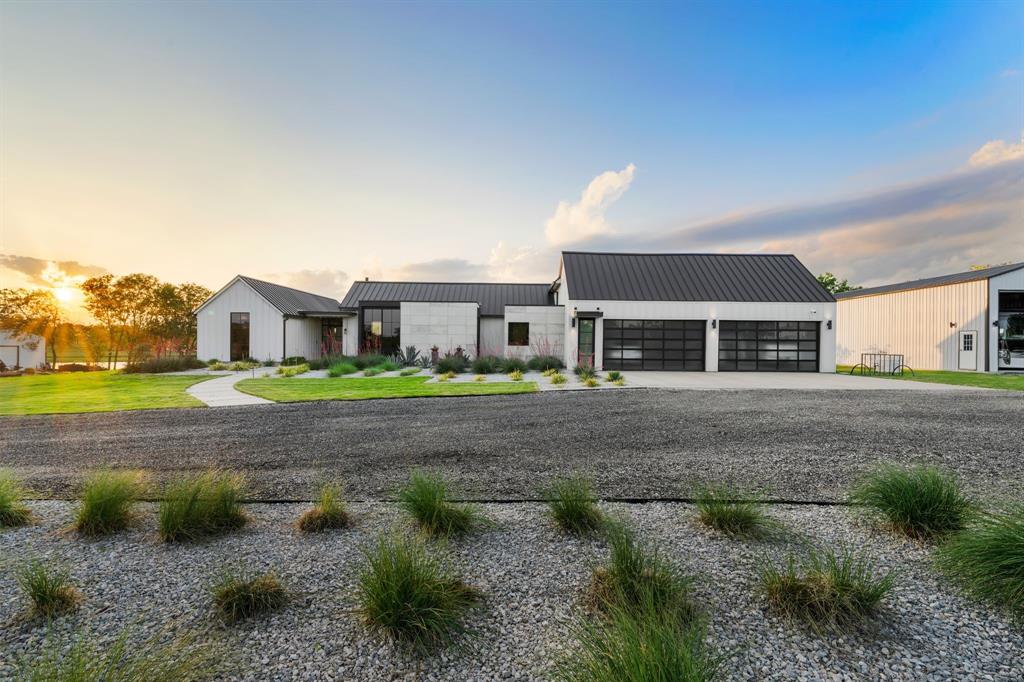 Welcome to this one-of-a-kind, high-end modern farmhouse where luxury meets function. Built with enduring quality and elevated design, this custom 4-bedroom, 3-bathroom masterpiece spares no detail. Every inch of this home is designed for elegant living, seamless entertaining, and long-lasting comfort.

Step inside to discover a warm and sophisticated interior featuring rich white oak hardwood flooring, motorized window shades, and a dramatic 20’ motorized glass wall opening to a fully conditioned porch—perfect for year-round enjoyment. Centered around a sleek 6’ linear propane fireplace with remote and blower, the open-concept living space shines under the glow of exquisite Reng handblown glass lighting imported from France.

The gourmet kitchen is a chef’s dream, outfitted with the Dacor Modernist Line of appliances, including a built-in 90-bottle Wine Tower, oversized integrated refrigerator, warming drawer, microwave drawer, and a stunning quartzite waterfall island. Thoughtful touches like Kohler fixtures, heated bidet commodes, motion detector floor lighting, and custom hideaway outlets ensure an unparalleled living experience.

Retreat to a luxurious owner’s suite with a custom-built headboard and bed, plus her closet that features an additional stackable washer and dryer for convenience. The home also includes a category 5 rated storm shelter, encapsulated attic, and backup generator —making this a true smart home built for durability, efficiency, and peace of mind.

Outside, the estate continues to impress with an oversized 4-car garage, a fully climatized RV bay, and a solar-assisted workshop that's air conditioned and insulated. The professionally designed xeriscape frames a breathtaking 3-acre stocked pond, grilling pavilion, open grassy areas, mature trees, and winding trails to explore—creating a private outdoor haven.

This is not just a home; it’s a lifestyle statement. Come experience modern farmhouse living at its finest.