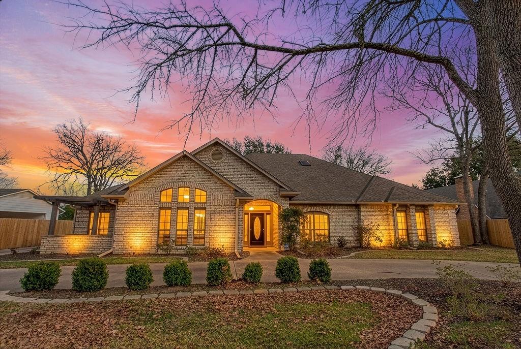 This beautifully updated home strikes that perfect balance between modern style and classic appeal, with generous rooms and smart design throughout. Pull up to the circular drive and feel the home's presence—it just has that welcoming, elevated look. Walk through the front door and the great room opens up before you with high vaulted ceilings, gorgeous wood beams, and a fireplace that really anchors the space. The custom built-ins add both function and character. It's the kind of room that impresses guests but still feels comfortable enough to actually live in. The kitchen is complete with stunning quartz countertops, and white porcelain tile floors. The appliances are top-notch—a Frigidaire Gallery double oven, JennAir cooktop, and even a built-in wine cooler. Three good-sized bedrooms, plus a fourth room that could work as another bedroom, media room, or office - ensures room for whatever you need. The primary suite feels like its own private world with a huge bedroom and a bathroom that rivals any spa: a double walk-in shower, plenty of vanity space, custom storage, and a large walk-in closet. The laundry room isn't an afterthought either—it has quartz counters, a built-in bookcase, and even a half bath attached. Then there's the second living area with floor-to-ceiling windows, automatic shades, and views of the beautiful backyard. There's more to love: the massive garage has 5 closets full of storage space. A rear entry and an extra-long driveway. If you want a refined home with serious space, gorgeous updates, and a community that feels like vacation year-round, this one checks every box. Hideaway residents enjoy access to resort-style amenities including 24-7 security, three scenic lakes, 27-hole golf course, tennis and pickleball courts, an Olympic-sized pool and adult pool, multiply parks, nature trails, a beach area, and a dog park—all just moments from your door. Hideaway is in Lindale ISD, known as one of the finest school districts in Texas.