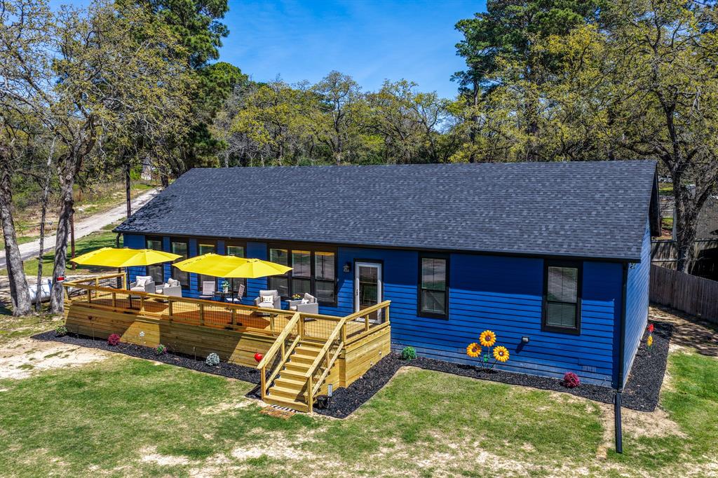 Searching for something truly one-of-a-kind? This exceptional waterview property delivers. Featuring a brand-new Franklin Homes modular residence & an extraordinary party barn, this turnkey retreat offers approximately 4,050 square feet of thoughtfully designed living & entertaining space. The 2,040 sq ft home showcases modern upgrades throughout, with 3 bedrooms, 2 baths, & a versatile flex room ideal for an office, gym, or additional guest space. Enjoy added peace of mind with a whole-home generator. The show-stopping 2,000 sq ft party barn—known as The Nest—is an entertainer’s dream. A 20x50 covered concrete apron provides ample space for parking & outdoor gatherings. Inside, discover “The Roadrunner,” your private sports bar, along with a cleverly designed indoor “outhouse” bathroom. Climate-controlled mini-split systems ensure year-round comfort in every room. Continue into “The Painted Pelican,” a creative studio with seating for 12, perfect for hosting art classes or hobby workshops. Hidden behind a secret bookcase lies “The Swanky Mallard,” a stunning speakeasy featuring a custom illuminated bar & ambient lighting that sets the perfect mood for entertaining. Additional highlights include expansive storage, three oversized garage doors, and RV space—ready for immediate enjoyment. Both structures are equipped with gutters for proper drainage, & a separate 50x100 grass lot offers room for storage or future expansion. Located in a community that allows short-term rentals, this property also provides access to a boat ramp on Lake Palestine, as well as a park, playground, and community center. Whether you’re seeking a personal retreat, investment opportunity, or both—this property is truly unforgettable!
