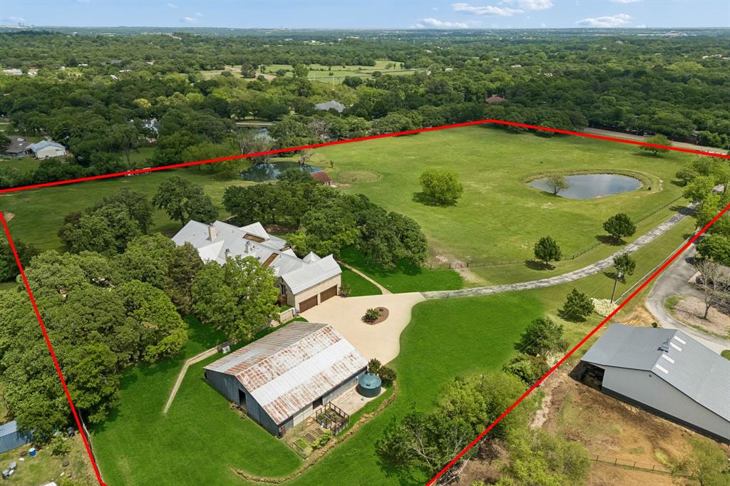 Set on scenic acreage in the heart of Argyle, this stunning farmhouse-style residence offers the perfect blend of rustic charm and expansive modern living. Designed with entertaining in mind, the open-concept layout seamlessly connects a grand living area to the kitchen and dining spaces, creating an inviting atmosphere that feels both spacious and warm. Every inch of this exceptional home delivers versatility and comfort—from the oversized bedrooms to multiple living and dining areas, a dedicated office or study, a large game room, and a fully equipped media room with a beautifully designed climate-controlled wine room for collectors and entertainers alike. Wellness and convenience are elevated with the addition of a private gym and relaxing sauna, while a complete surround sound and alarm system enhances both ambiance and security throughout the home. The upstairs oversized primary suite is a true retreat, featuring abundant natural light, a luxurious en-suite bath with a cozy built-in fireplace, and an extended two-story walk-in closet that offers exceptional storage. Beyond the home, the property continues to impress with a massive 60x90 shop—ideal for hobbies, storage, or business use—while the surrounding acreage provides peaceful views and room to roam. The charming barn on-site adds both character and versatility, and an automated gate provides both privacy and ease of access. 7700 FM 1830 presents a rare opportunity to enjoy refined country living without sacrificing space, style, functionality, or modern amenities.