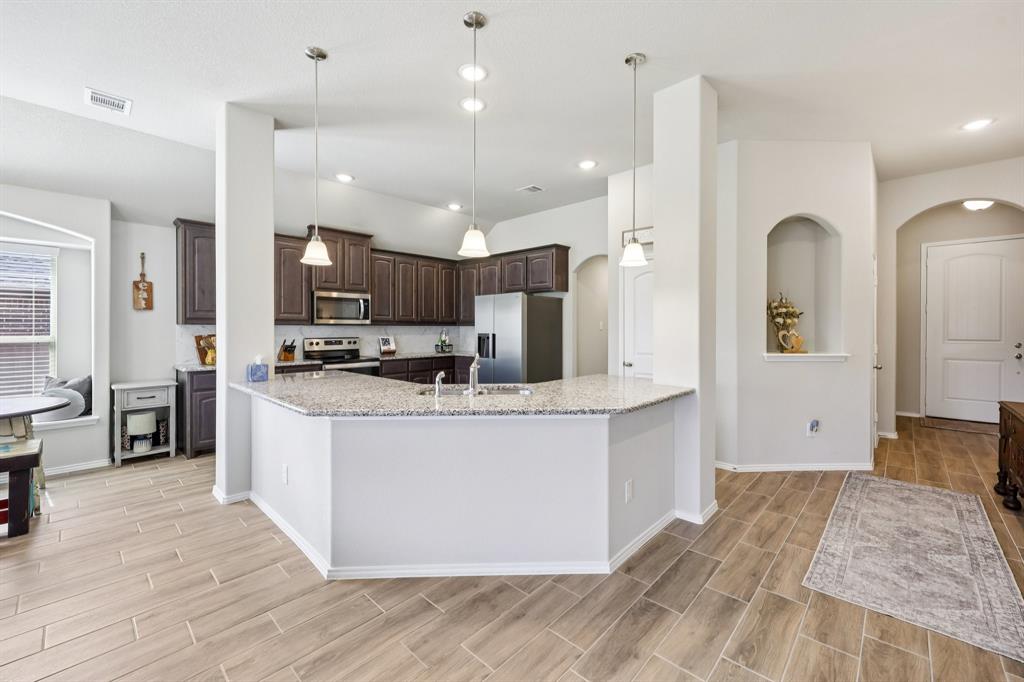 Welcome to 212 Magnolia Drive.  A beautifully crafted Antares Home that blends modern finishes, thoughtful design, and effortless functionality. Ready now, this stunning open-concept floor plan was designed with both everyday living and entertaining in mind.
From the moment you step inside, you’re greeted by gorgeous wood-look tile flooring that flows seamlessly throughout the main living spaces, offering both durability and style. The expansive family room opens directly into a chef-inspired kitchen that truly serves as the heart of the home.
The kitchen features:
 An impressive 11-foot island with elegant pendant lighting, Granite countertops, Stainless steel appliances,  Abundant cabinetry and prep space, A large walk-in pantry.
Whether hosting gatherings or enjoying a quiet night in, this space was made to bring everyone together.
Privately set at the back of the home, the exclusive primary suite offers a peaceful retreat. Vaulted ceilings create an airy, luxurious feel, while the spacious layout allows for a true relaxation zone at the end of each day. 
The en-suite bath is equally impressive with:
Dual sink vanity, Separate walk-in shower,  Oversized garden tub, Expansive walk-in closet.
Two additional bedrooms are thoughtfully positioned in their own wing, ideal for children, guests, or even a home office setup. They share convenient access to a full bath, providing comfort and privacy for everyone.
Additional highlights include:
Covered back patio perfect for outdoor entertaining, Full-size utility room with direct access to the two-car garage, Functional layout designed for privacy and convenience. Smoke and pet free . 
This home offers the perfect balance of style, space, and smart design — all in the growing Azle community.