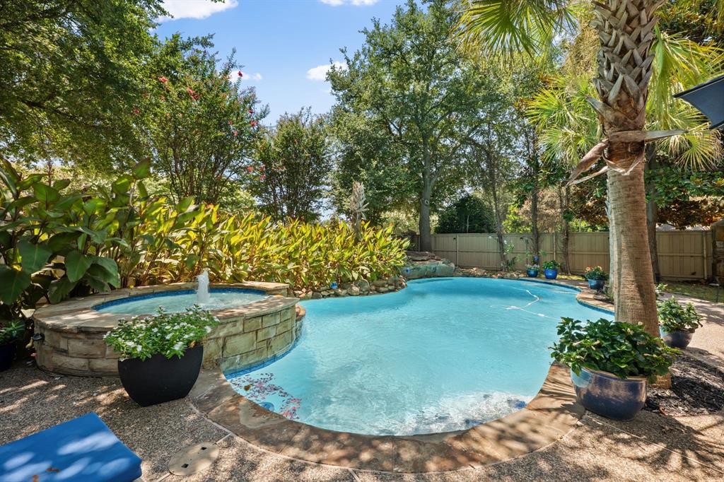 Located in Arbor Hollow within Stonebridge Ranch, this beautifully maintained home offers room to spread out, room to entertain, and a backyard with a pool that's ready for summer! Filled with natural light and soaring ceilings, the floor plan is designed to accommodate both everyday living and entertaining with multiple living areas, a dedicated office, a private first-floor primary suite, and a large upstairs bonus room. The main level features a welcoming sitting area, formal dining room, private study with double doors, and a spacious living room with surround sound overlooking the backyard. At the center of the home, the kitchen offers granite countertops, stainless steel appliances, an island for cooking, a wine fridge, an oversized pantry, and abundant storage. Situated on the first floor, the primary suite enjoys views of the backyard and includes a spacious ensuite bath with a soaking tub, separate shower, and large walk-in closet. Upstairs, you'll find three additional bedrooms, including one with a private ensuite bath, along with a versatile bonus room behind French doors that can easily serve as a game room, media room, or second living area. The backyard is built for making memories, with a heated pool and spa, waterfall feature, and palm trees creating the perfect setting for summer afternoons, evening gatherings, and year-round enjoyment. Fresh interior paint provides a move-in-ready feel. Additional updates include newly replaced central AC systems, newly installed water heaters, and a new AquaLink wireless pool management system for convenient pool and spa control. The three-car garage has epoxy floors, storage cabinets, and overhead storage racks for extra storage. As a Stonebridge Ranch resident, you'll enjoy access to community pools, tennis and pickleball courts, parks, walking trails, and year-round events, all conveniently located near Highway 121, Highway 75, shopping, dining, golf, and entertainment!