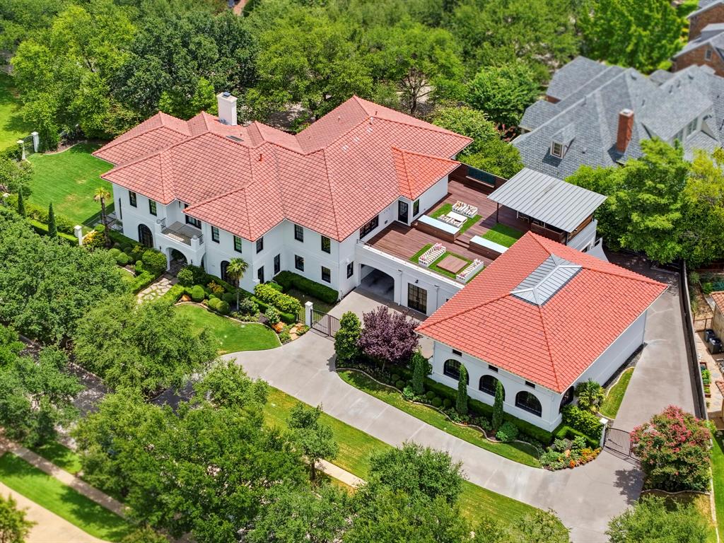 Welcome to a truly one-of-a-kind residence in the exclusive gated community of Trinity Heights, where bold architectural design meets timeless sophistication. Gracefully positioned on two expansive lots beside a picturesque greenbelt, this extraordinary 4-bedroom, 5.5-bath estate was thoughtfully curated for both everyday luxury and unforgettable entertaining. Every space tells its own story, from custom murals, designer wallpaper, and statement lighting to sun-drenched living areas framed by expansive windows, all seamlessly woven together into a cohesive, elevated aesthetic. Designed for exceptional living, the home features three spacious living areas, two elegant dining spaces, and elevator access to every level, blending convenience with refined luxury. A private fitness studio overlooks a versatile multi-use sport court with basketball or pickleball capabilities, while multiple balconies, including a spectacular two-level, partly covered terrace, create a seamless indoor-outdoor living and unforgettable spaces to relax or entertain. The spacious lawn offers endless opportunities for recreation, pets, or future outdoor enhancements, further elevating the estate's impressive grounds. Car enthusiasts and hobbyists alike will appreciate the remarkable seven-car garage with abundant storage, providing exceptional space for prized collections, recreational equipment, or workshop needs. Every detail has been thoughtfully considered to create an unparalleled living experience where striking architecture, designer finishes, and functional luxury exist in perfect harmony. Distinctive, refined, and impossible to replicate, this extraordinary residence is more than a home; it is a statement of uncompromising luxury, exceptional craftsmanship, and elevated living in one of the area's most coveted gated communities.