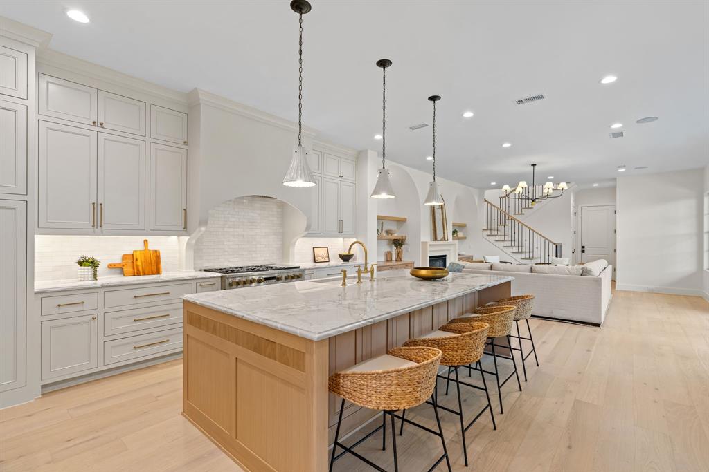From the moment you arrive, the striking architecture of this Transitional Modern residence with Tudor inspired elements creates an unforgettable first impression. Inside, soaring ceilings, warm wood floors, and expansive windows fill the home with natural light, creating an inviting and elegant atmosphere.

The heart of the home seamlessly connects the kitchen, living, and dining spaces, designed for both everyday living and entertaining. The oversized island naturally becomes a gathering place, while the chef’s kitchen features panel ready appliances, a 48 inch range, designer finishes, and custom details throughout.

Whether hosting by the fire or enjoying a quiet evening at home, the space feels both grand and comfortable. A private study offers the perfect work from home retreat, while the nearby wet bar makes entertaining effortless.

The primary suite is a peaceful escape with a spa inspired bath featuring calming textures and luxurious finishes. Every detail of this custom 2026 residence was thoughtfully designed to create a home that feels sophisticated, welcoming, and truly exceptional.