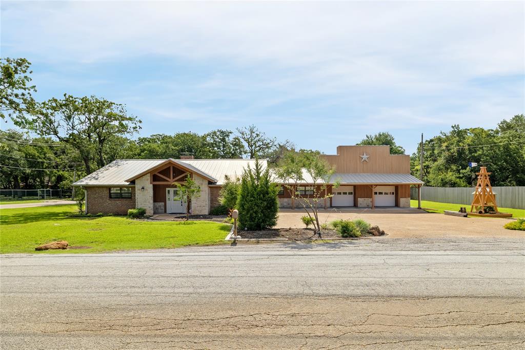 Rare Half-Acre Corner Lot Custom Home Minutes from Arlington’s Top Attractions! This exceptional property offers the perfect blend of custom craftsmanship, spacious living & versatile entertaining spaces, all just minutes from Globe Life Field, Texas Live!, AT&T Stadium & Six Flags Over Texas. Situated on a beautifully landscaped half-acre corner lot, this one-of-a-kind home showcases timeless details including wood floors, soaring cathedral pine ceilings w exposed beams, wainscoting & a stunning stone fireplace anchoring the living room. The thoughtfully designed split-bedroom floorplan features 4 bedrooms & 4 bathrooms, including a private guest suite w ensuite bath & a luxurious primary retreat complete with an ensuite bathroom, oversized walk-in closet & dedicated office or flex space perfect for a home gym, studio, or additional workspace. The heart of the home is the expansive parlor-style kitchen featuring abundant granite countertops, extensive cabinetry & an enormous bar-height breakfast island w room for casual dining, additional living space & wiring for a mounted flat-screen TV. The spacious family room overlooks the backyard and provides the ideal setting for gatherings and everyday living. Car enthusiasts, entertainers & hobbyists will appreciate the oversized 4-car garage featuring a metal ceiling, offering endless possibilities as a party barn, workshop, game area, or ultimate vehicle sanctuary. Attached guest quarters with a separate garage entry provide incredible flexibility with an open-concept layout featuring a kitchen, living area, bedroom or gameroom space & full bathroom—perfect for guests, multigenerational living, or a private retreat. Step outside to enjoy the expansive backyard with mature trees, a large covered porch & generous patio space designed for entertaining. With plenty of parking, additional driveway space, and an unbeatable location, this custom home delivers a rare combination of Character, Functionality & Convenience.