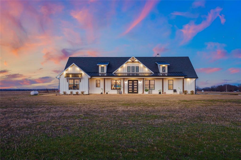 Follow your dreams and turn them into reality on this extraordinary 13.5-acre AG EXEMPT property, where possibilities are endless. Offering the rare flexibility to build multiple homes, create a private family compound, or design the retreat you’ve always envisioned, this one of a kind property combines freedom, function, and luxury country living. The land is unzoned and features multiple electrical services with three 200AMP breaker panels, providing ample capacity for an oversized garage, workshop, or ADU. A large aerobic septic system, private well with automatic pump system, RV septic hookup, and propane tankless water heaters provide low maintenance utilities. Escape to the perfect blend of luxury and country living with this stunning modern farmhouse, set amid sweeping hay fields. The expansive front porch creates unforgettable curb appeal and welcomes you home from the moment you arrive. Inside, soaring vaulted ceilings, sun filled spaces, and an impressive open layout welcome you home. With 4 spacious bedrooms and 4 beautifully designed bathrooms, there’s room for both everyday comfort and effortless entertaining. Oversized windows frame breathtaking countryside views while flooding the interior with natural light. Every detail reflects rustic elegance, from warm finishes to airy, flowing spaces. Step onto the back porch to savor peaceful mornings, evenings, and uninterrupted views of your private acreage. The land is fully fenced ideal for cattle, horses, or recreation. In addition to the tranquil setting, you’re just minutes from Gainesville and I-35, Lake Ray Roberts and less than an hour from Lake Texoma. Whether you’re seeking a full time residence, weekend escape, or multigenerational homestead, this property offers the rare opportunity to live beautifully and freely under wide open Texas skies.