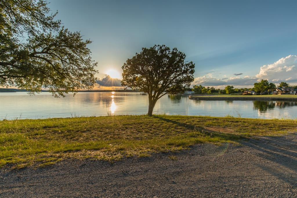 Updated and furnished lake home with sweeping, wide-open views of Possum Kingdom Lake! Ideally situated in the heart of Golden Cove—within easy walking distance to the community boat ramp and swim cove—this prime location lets you soak in lake living from sunrise to breathtaking sunsets, all from a spacious, grassy front yard.

Golden Cove offers a true sense of community along with excellent amenities, including access to the swim cove, boat ramp, community dock, pavilion, and neighborhood events that make lake life even more enjoyable.

After a full day on the water, retreat to this cozy and well-maintained home featuring an open-concept living and kitchen area, an inviting enclosed sunroom, and four bedrooms, with room for a large family or plenty of guests. Out back, you’ll find a shaded oasis beneath a majestic oak tree—perfect for grilling, relaxing, and entertaining—fully enclosed by a wooden privacy fence. A newly added (2024) carport provides two covered parking spaces for vehicles or your boat.

The sellers have lovingly cared for this property, painting the exterior and making plumbing improvements in recent years. This is leased land with a current monthly lease fee of $915; the landowner pays the lot taxes. Deeded properties with views like this at Possum Kingdom Lake are increasingly rare and typically come with a much higher price tag.

Come see it for yourself and get into your own lake place before Summer!