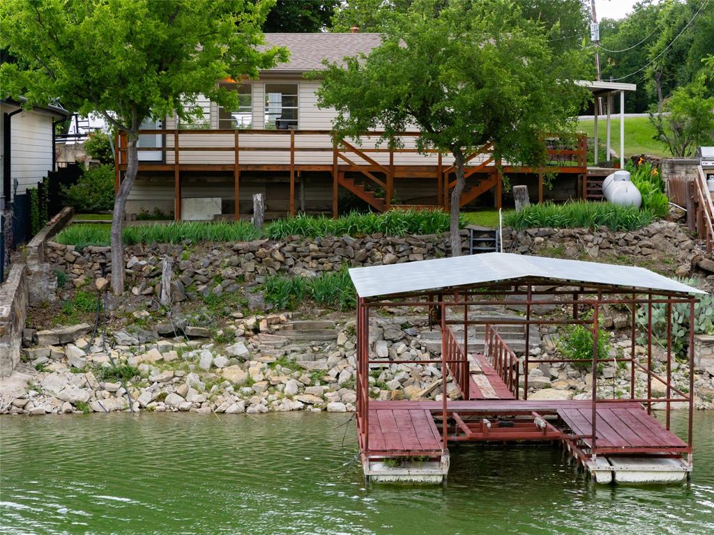 Escape to the lake with this clean, well-maintained waterfront retreat on a deep-water slough! Located at 121 Lure Street in Bridgeport, this charming 1-bedroom, 1-bath home offers 704 square feet of easy living with the kind of setting that makes every day feel like a getaway. Inside, you’ll find light wood-look laminate flooring, a bright and inviting interior, and beautiful water views from nearly every window. The home has been lovingly cared for and offers comfortable heating and cooling with efficient window units. Step outside and enjoy the best of lake life with a spacious covered porch, large open deck, and your own private boat slip—perfect for fishing, boating, or simply relaxing by the water. Lovely landscaping adds to the peaceful, welcoming feel of the property. Whether you’re looking for a weekend escape, investment opportunity, or full-time lakefront lifestyle, this property delivers on what matters most: location, water access, and views. Conveniently located just 15 minutes from downtown Bridgeport for shopping, dining, and everyday amenities, and a little over an hour from Dallas Fort Worth International Airport, you can enjoy the perfect balance of peaceful lake living and city convenience. Voluntary HOA. Buyer to verify all information, including flood insurance requirements.