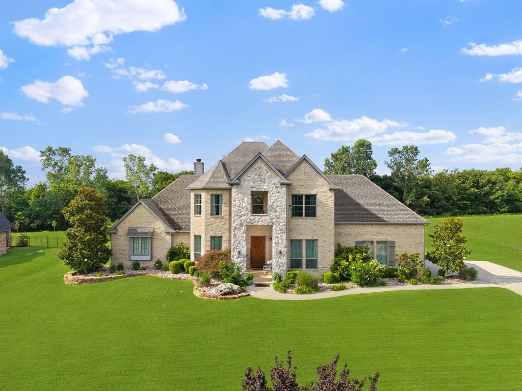 Tucked inside the prestigious gated community of Waterstone Estates, this beautifully cared-for one-acre retreat offers a rare blend of elegance, privacy, and possibility. The moment you arrive, the home feels polished, peaceful, and intentional; surrounded by mature trees, pristine landscaping, and the quiet beauty of acreage living in McKinney. Inside, the home is showroom-ready, with muted colors and spaces designed for modern families, professionals, and creatives. The main level features one bedroom and a large private office with French doors, creating an ideal work-from-home setting without sacrificing a bedroom. The primary suite is a true sanctuary featuring a stunning, vaulted groin ceiling which adds architectural drama and quiet luxury. The ensuite sparkles with all-Italian Carrara marble countertops, oversized vanity, mirror, and a spacious spa-inspired double shower. A dedicated home office, powder room, and large utility room with mud area round out the first level. An EF5-rated Family Safe storm shelter with reinforced concrete beneath offers peace of mind. Upstairs two additional bedrooms and a generous second living area, designed in lieu of a fourth bedroom, create space for movie nights, a lounge, or game room. Beyond that, an approximately 400SF air-conditioned flex space with a private door opens to countless uses such as tucked-away office, fitness, or creative escape. Outside a pristine backyard framed by mature landscaping and trees awaits your vision for the perfect peaceful backyard sanctuary, resort-style pool, outdoor kitchen, or garden pavilion. A freshly painted covered patio with a large fan overlooks a tapestry of mature trees that invite you to sit beneath the sweet symphony of birds chirping. At Waterstone Estates, you can enjoy space to breathe and still be within minutes from the charm of Historic Downtown McKinney, nearby H-E-B, Chipotle, Chick-fil-A, Hwy 75, Sam Rayburn Tollway, 380, + McKinney National Airport (TKI).
