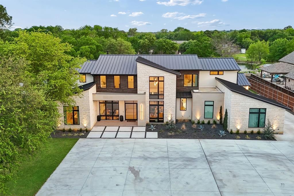 Experience luxury living in this stunning modern new construction by MCM Custom Homes, perfectly situated on a private 1.14-acre lot with no HOA. Spanning 5,223 square feet, this thoughtfully designed home features 5 bedrooms, each with its own ensuite bath, plus a conveniently located powder bath for guests. The primary suite and an additional guest bedroom are located on the main level, ideal for comfort and flexibility. The open-concept layout is highlighted by a chef’s kitchen with Thermador appliances, a striking waterfall island, custom cabinetry, and designer LED lighting throughout. Living and dining areas seamlessly connect to a spacious covered patio featuring a push-button fireplace, outdoor kitchen, and drop-down screens, creating effortless indoor-outdoor living. Designed for entertaining, this home includes Sonos audio throughout, a game room with bar, and a dedicated media space on the main level. Car enthusiasts will appreciate the 4-car garage with epoxy flooring and wiring for an electric vehicle charger, along with a separate golf cart garage. Built with quality and efficiency in mind, the home features a standing seam metal roof and is fully foam encapsulated for enhanced energy efficiency. Fully fenced and gated, this exceptional property offers both privacy and convenience in a prime location between city park and the Colleyville Nature Center. Enjoy peace of mind with 10 hardwired cameras and DVR system for safety and security. This rare property blends modern design, luxury finishes, and functional living—all without HOA restrictions and just minutes from DFW airport.