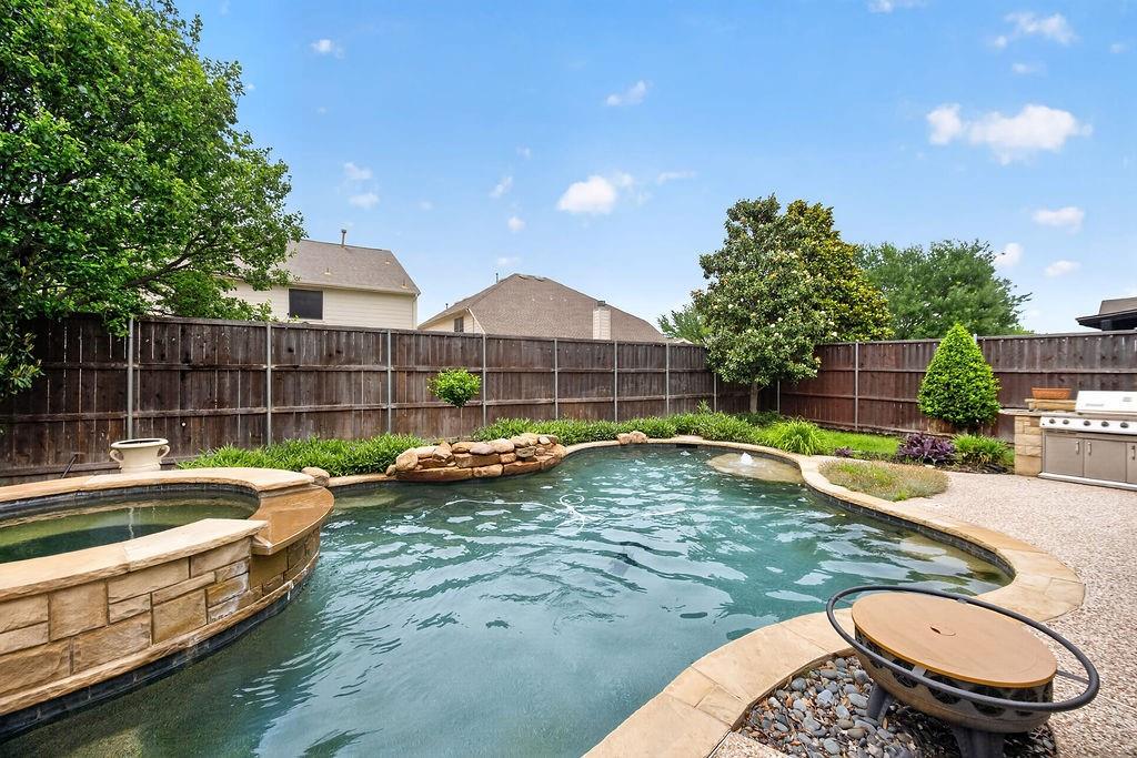 Rare find in Brookstone! Discover the perfect blend of traditional elegance and modern convenience in this stunning 4-bedroom Frisco ISD home. Designed for those who love to host, this property seamlessly balances sophisticated indoor living with a spectacular outdoor sanctuary.The open-concept interior flows effortlessly into a gourmet kitchen featuring premium granite countertops and a center island, complemented by a bonus built-in desk in the living area and a dedicated home office—perfect for today’s remote professional. Rich engineered hardwoods and elegant crown molding lead you through a floor plan that feels both grand and inviting. Upstairs, an expansive open loft provides a flexible second living area that can easily be utilized as a media or theatre space.The real showstopper is the private backyard retreat. Step outside to your own vacation-at-home destination featuring a refreshing gunite play pool and spa with a pebble-tech finish and water features. You can entertain with ease using the full outdoor kitchen, complete with a built-in flagstone grill and prep station under a spacious covered patio. With a rare 3-car garage and a prime location just a short stroll from Elliott Elementary, this home is a true lifestyle upgrade.