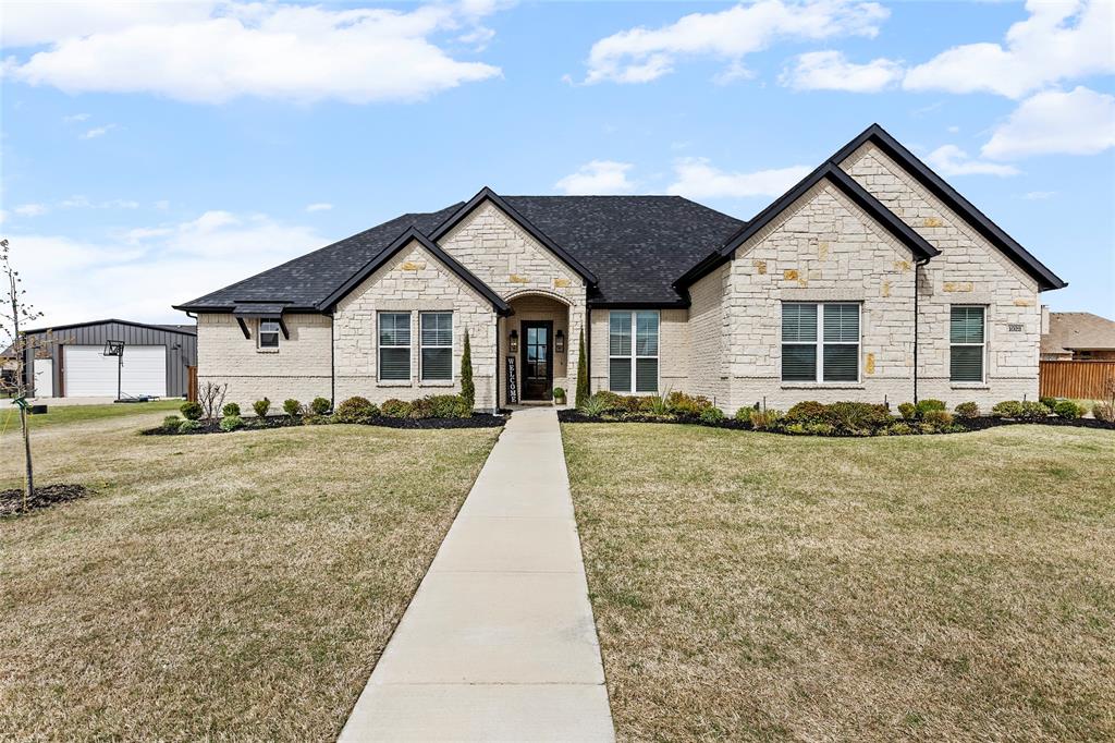 Plenty of space in new established first class subdivision with this custom 4 Bedroom 3.5 Bath with additional bonus room & office space located in the exclusive The Mills. This beautiful home features a Brick and Stone exterior is located on over large .5  acre lot for plenty of space. Inside you find open concept living space, vaulted ceiling, custom built-in entertainment center, white stone gas fireplace and custom hand scrapped hardwood floors thru the main living area. The extra large marble island (with eating area) highlights the spacious kitchen that offers a gas cooktop, built in stove & microwave, walk-in pantry, custom cabinetry to the ceiling and much more. The large primary bedroom features tray ceilings, ceiling fan, barn door entering  a ensuite bath area with jetted tub, separate walk-in shower, dual vanities and sinks with custom his and hers walk-in closet that opens to a large laundry room with linen closet and exits to a mudroom near the garage entry. The other primary features marble sink and walk-in shower. The 3rd and 4th bedrooms each have their own walk-in closets, private vanities with sinks & sharing the Jack & Jill bath. Located near the entry of the home you have a Bonus Room that is perfect office space, a playroom or many other options. This home has numerous custom features throughout such as engineered foundation post tension, heat pump HVAC, 2 tankless water heaters, cellulose all stay insulation, 8' doors, marble countertops, irrigation system and large windows allowing for an abundance natural lighting. The oversized garage allows parking as well as plenty of storage space. Located on the back patio you have additional gas stone fireplace with TV and hookups for propane stove offering a great area for relaxing and  entertaining. The private backyard has a custom wood privacy fencing and a dog run. Located with very easy access to I30 (Greenville & Rockwall) restaurants & shopping, schools, daycare and the heart of Caddo Mills Tx