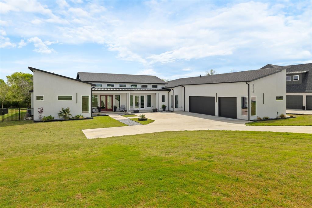 Custom built modern one-story home you don't want to miss! This home showcases soaring 14-ft ceilings with exceptional natural light, and a seamless connection to its serene outdoor setting with pond and creek views. Designed for both comfort and sophistication, this home features a separate in-law or kids suite featuring a living area, two bedrooms with ensuite baths, one with private porch access, 1,000 sq ft of garage space with floored attic storage, and over 1,100 sq ft of inviting porches. Inside, three spacious bedrooms each offer large ensuite baths, complemented by a versatile game or media room, a dedicated study with built-ins and private porch access. The gourmet eat-in kitchen impresses with a walk-around pantry featuring custom cabinetry and floating shelves, a 48-inch KitchenAid range with griddle, pot filler, and an exotic granite island. Expansive high windows and a dramatic 16-ft sliding glass door flood the home with light and frame views of the treed backyard. Luxurious touches include motorized shades throughout most of the home, a motorized UV solar screen with wind sensor on the front porch, oversized barn doors leading to the secondary suite, and barn doors on the study which features a private porch. Thoughtfully designed oversized laundry room with an abundance of cabinetry, built-ins and separate desk area. Full encapsulated spray-foam insulation, metal-roof porches, and beautiful large-format tile in all main living spaces complete this refined, energy-efficient property with room to expand. Beyond the fenced in backyard is a serene pond with creek access, and additional space for building a separate workshop or accessory building.