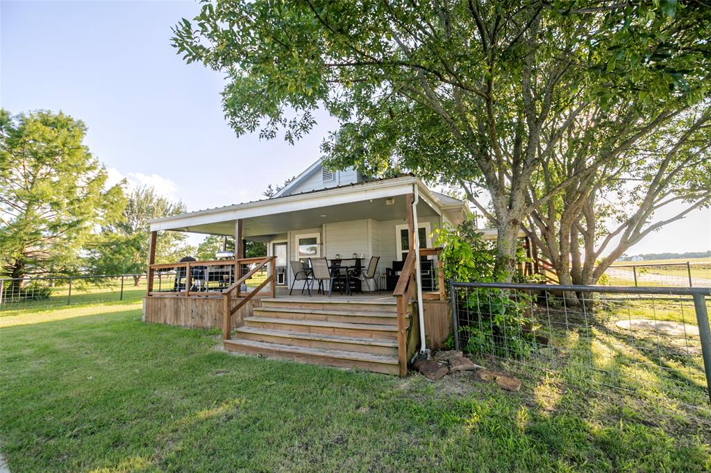 Completely remodeled farmhouse on 2 beautiful acres featuring a private pond, detached office with energy efficient mini split system, large workshop with electric, mature trees, producing peach trees, and countless upgrades throughout! This charming 3-bedroom, 2-bath home offers the perfect blend of modern convenience and country living. Step inside to find a warm and inviting living room highlighted by stunning Arkansas ash wood from floor to ceiling and a gorgeous floor to ceiling rock wood-burning fireplace. The kitchen features real wood cabinetry and ample space for gathering with family and friends. Major improvements provide peace of mind, including updated electrical wiring and panel, spray foam insulation in the walls and flooring throughout half of the home, a roof approximately 4 years old, and an HVAC system approximately 4 years old. Outside, you’ll discover your own private oasis. Enjoy peaceful mornings overlooking the backyard from the large covered back deck, tend to the established garden, collect fresh eggs from the chicken coop, sit on the dock by the pond or simply relax beneath the shade of the many mature trees. The expansive covered back deck and large wraparound deck extend from the side of the home to the back, creating the perfect space for entertaining and enjoying the scenic surroundings. The property is also fully fenced for added privacy and functionality. For those needing extra space, the property includes a detached 23 x 11 office—ideal for working from home—as well as an impressive 28 x 60 workshop-garage with electricity, offering endless possibilities for hobbies, storage, equipment, or business use. Permanent exterior lighting enhances the home’s beauty and curb appeal year-round. If you’ve been searching for a move-in-ready country property with room to live, work, and play, this exceptional farmhouse offers the lifestyle you’ve been dreaming of.